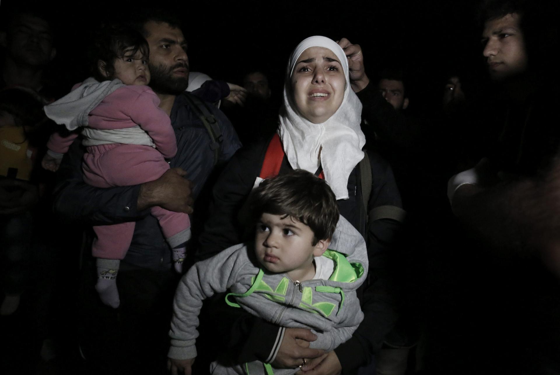 YAN38 KOS (GRECIA) 06/05/2015.- Refugiados sirios recién desembarcados esperan a los guarda costas en la isla de Kos (Grecia) cerca de la frontera con Turquía el 6 de mayo de 2015. Grecia recibe una media diaria de cien inmigrantes y refugiados, aunque hay jornadas en que llegan varios centenares de personas, mayoritariamente por mar desde Turquía. Solo en el primer trimestre del año se registraron 10.445 llegadas de inmigrantes, de acuerdo con las cifras de la Guardia Costera. Grecia es una de las principales puertas de entrada para los que quieren acceder a territorio europeo, por lo que el Ejecutivo ha pedido en repetidas ocasiones más apoyo a sus socios con el fin de gestionar el flujo de personas que llegan por vía marítima, tras asegurar que los guardacostas están desbordados. EFE/Yannis Kolesidis