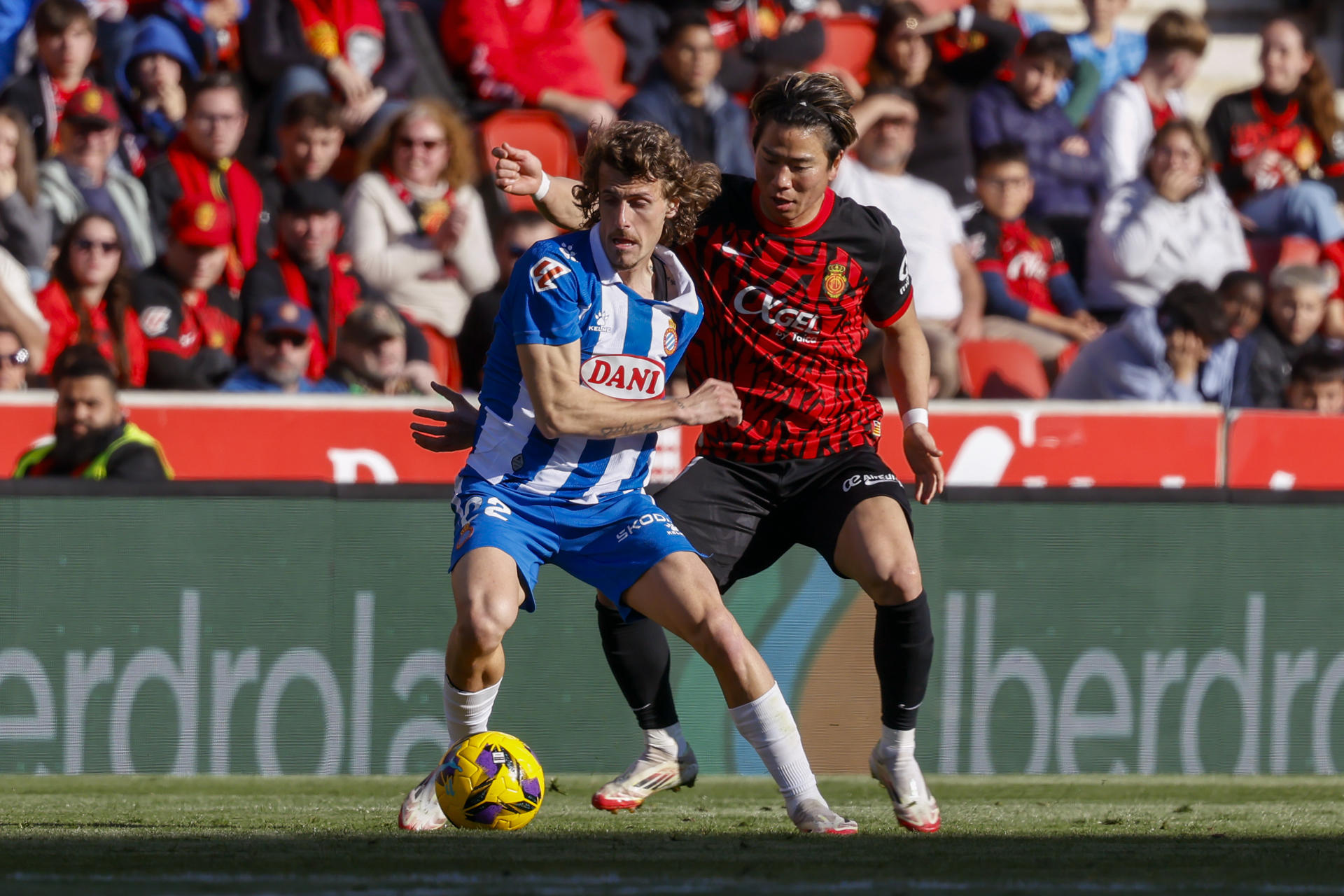 El defensa del Espanyol, Carlos Romero (i), con el balón ante el delantero del Mallorca, Takuma Asano, en el estadio de Son Moix en foto de archivo de CATI CLADERA.EFE