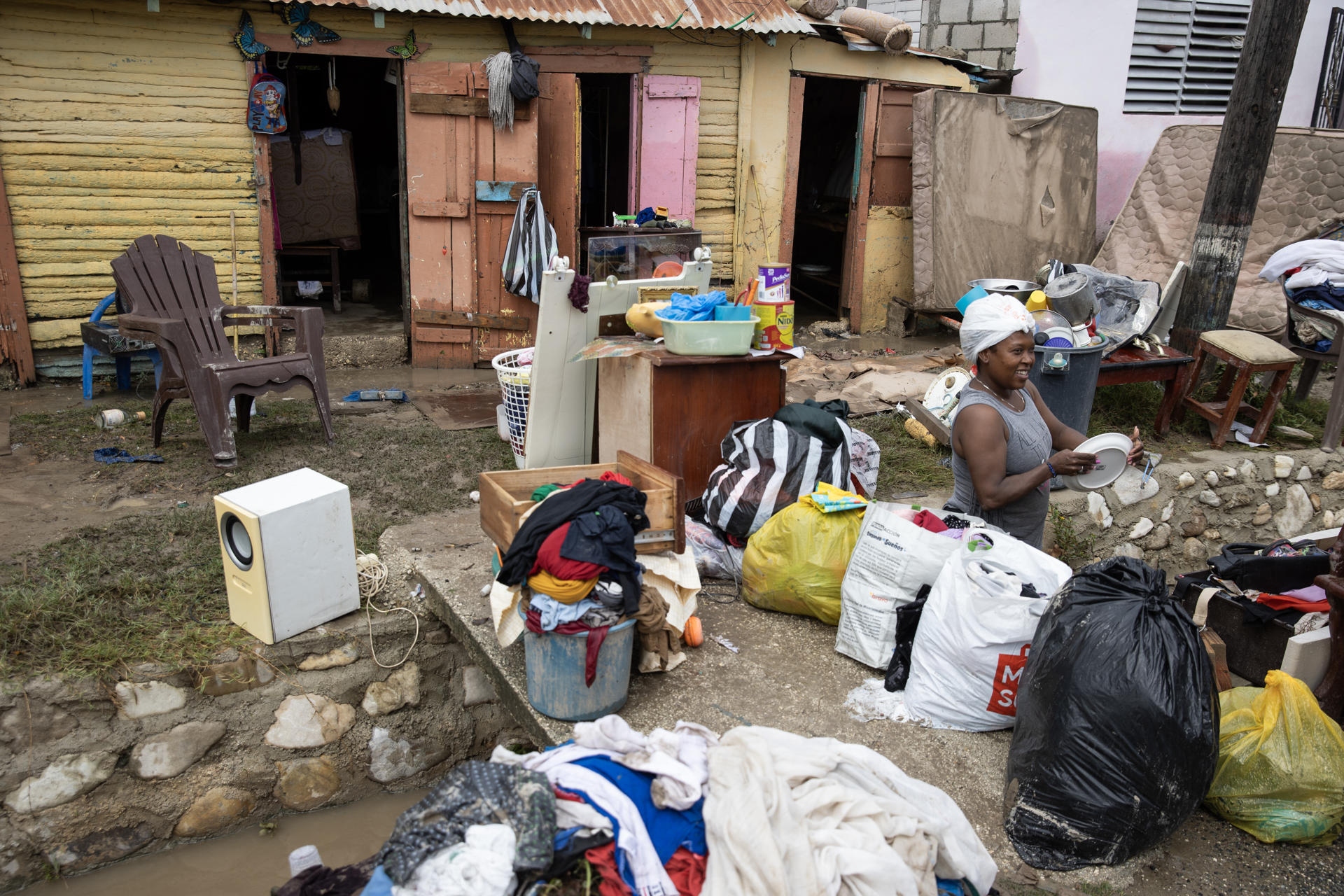 Personas secan sus pertenencias luego de una inundación este viernes, en Azua (República Dominicana). EFE/ Orlando Barría

