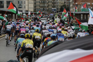 -El pelotón pasa ante las personas concentradas en protesta por la situación de Gaza , al inicio de la etapa 16 de la Vuelta Ciclista a España que se disputa este martes entre Poio y Mos-Castro de Herville (Pontevedra), de 167.9 km de recorrido. EFE/Lavandeira