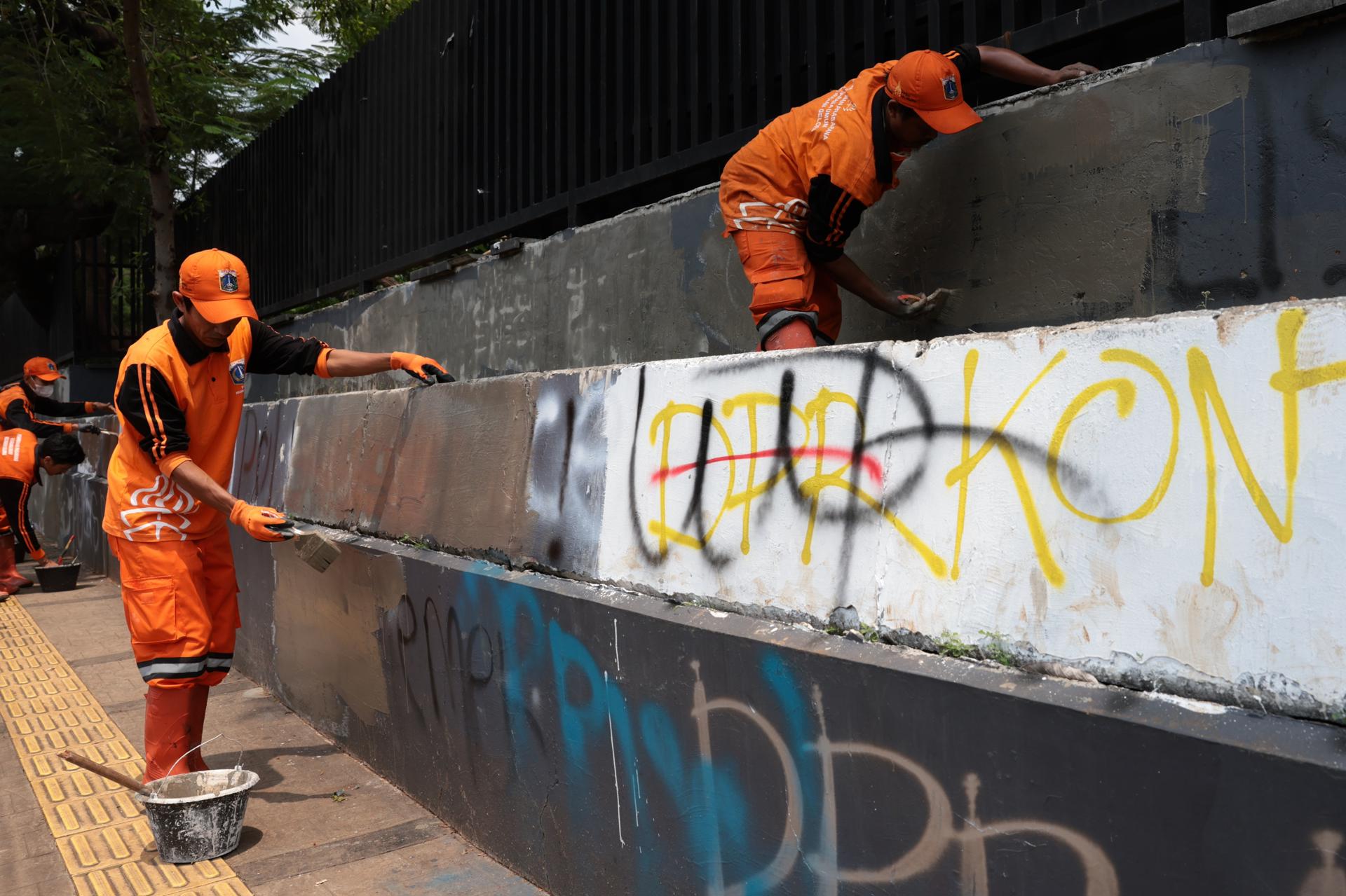 YAKARTA (Indonesia), 01/09/2025.- Trabajadores retiran grafitis tras las protestas frente al Parlamento en Yakarta. EFE/EPA/ADI WEDA