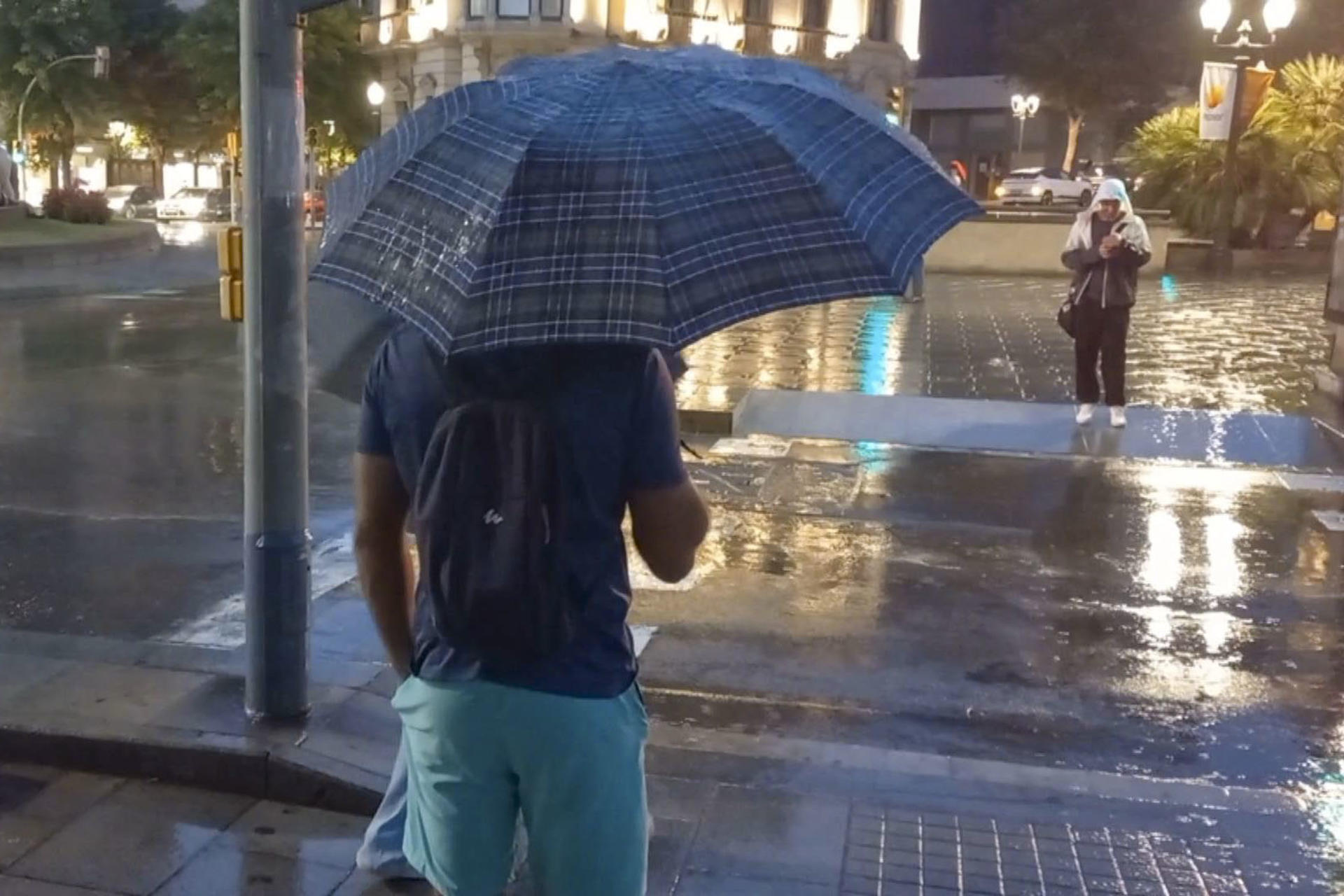Varias personas bajo la lluvia en Tarragona, este lunes.