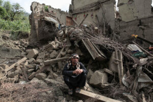 Una víctima del terremoto sentada junto a los escombros de una casa dañada este miércoles en Kunar (Afganistán). Al menos 1400 personas han muerto tras un terremoto de magnitud 6,0 y varias réplicas que sacudieron Nangarhar y Kunar, en el este de Afganistán, durante la noche, según informaron las autoridades. EFE/EPA/SAMIULLAH POPAL