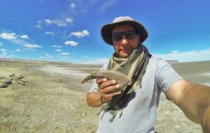 El investigador Marcelo Luna sostiene una garra de megaraptor. Marcelo Luna/z, Universidad Nacional de la Patagonia San Juan Bosco