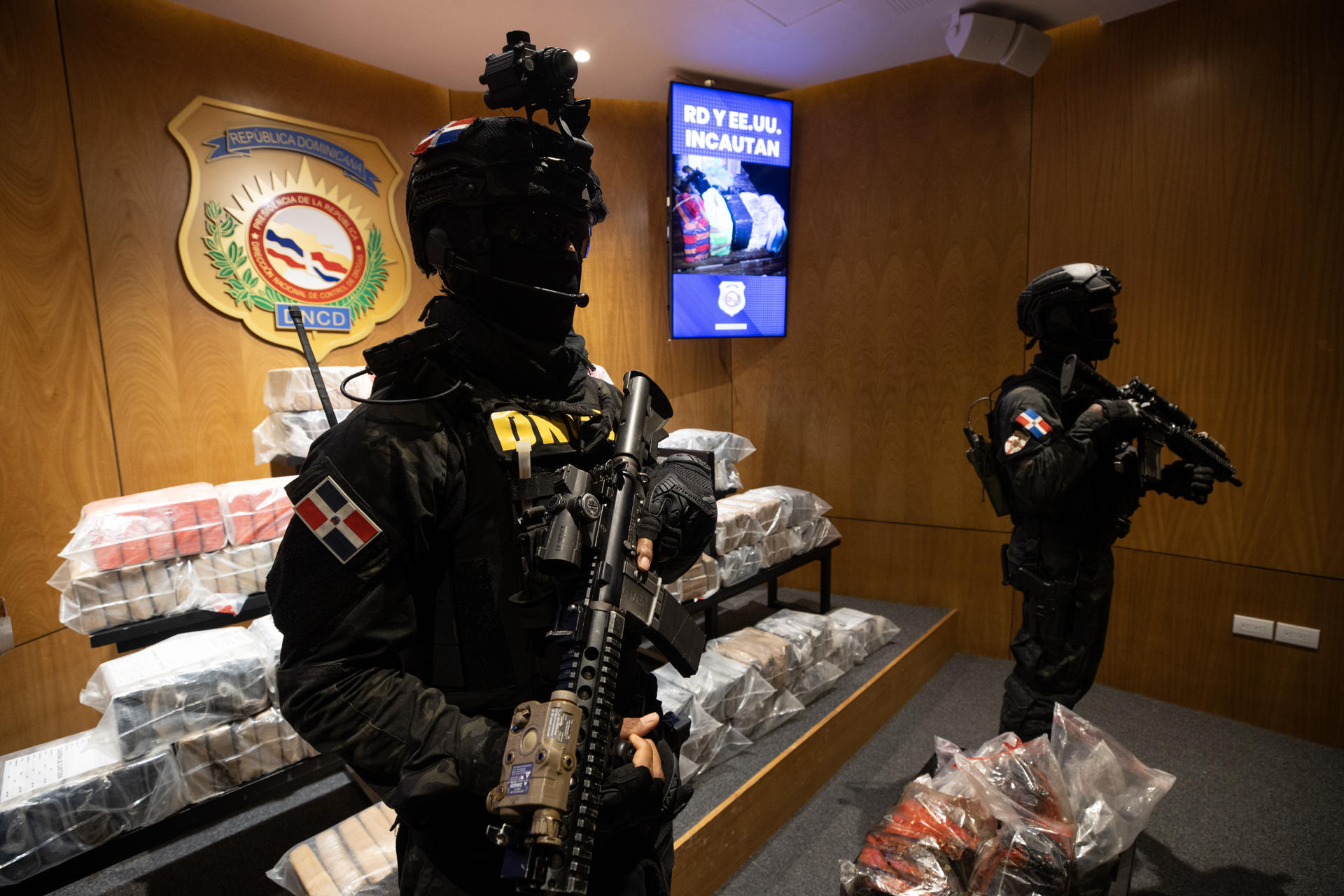 Integrantes de la Dirección Nacional de Control de Drogas (DNCD) de República Dominicana fueron captados este domingo, 21 de septiembre, al custodiar 377 paquetes de la presunta cocaína que iba a bordo de la más reciente embarcación bombardeada por el Ejército los Estados Unidos en aguas del mar Caribe, en Santo Domingo (República Dominicana). EFE/Orlando Barría