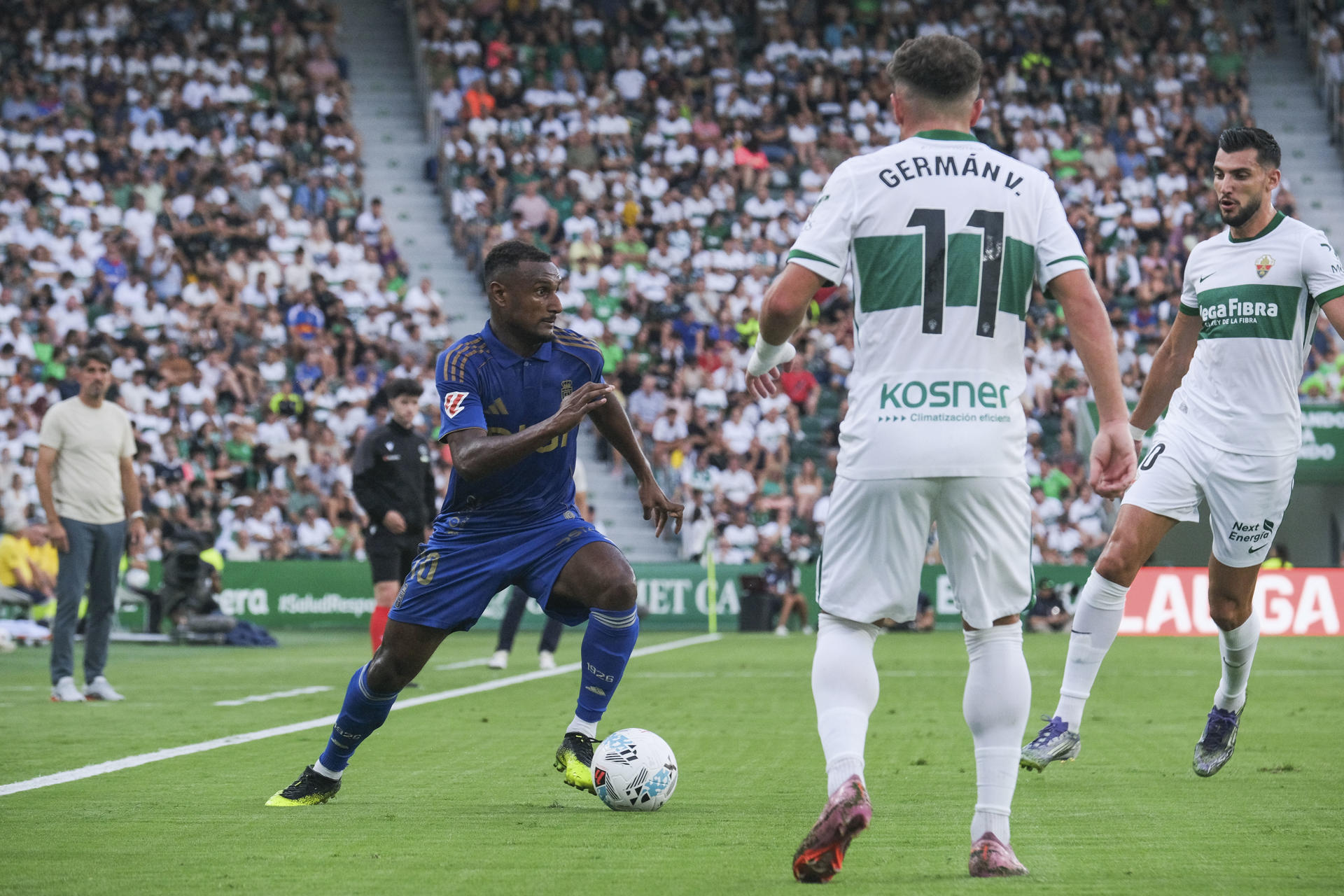 El centrocampista francés del Oviedo Haissem Hassan (i) controla el balón ante German Valera (c), del Elche, durante el partido de la quinta jornada de LaLiga que Elche CF y Real Oviedo disputaron en el estadio Martínez Valero. EFE/ Pablo Miranzo.