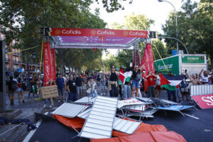 Los manifestantes propalestinos cortan el recorrido de los ciclistas en el Paseo del Prado, este domingo, durante la última etapa de la Vuelta a España que se disputa entre las localidades madrileñas de Alalpardo y Madrid, con un recorrido 103,6 Km.- EFE/Rodrigo Jiménez