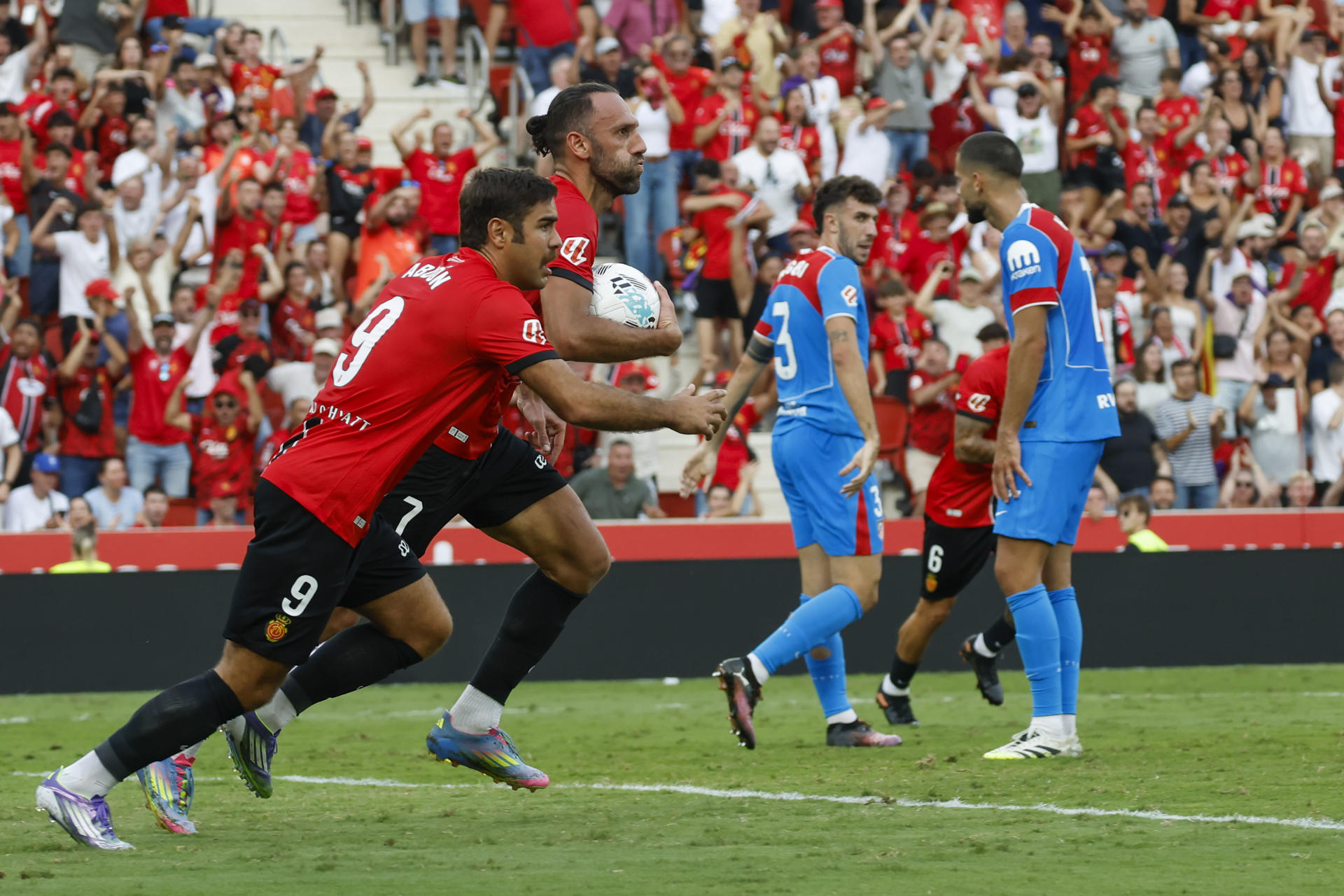 El delantero kosovar del Mallorca Vedat Muriqi (2i) celebra tras anotar un gol este domingo, durante el partido de la jornada 5 de LaLiga EA SPorts, entre el Real Mallorca y el Atlético de Madrid, que se disputó en el estadio de Son Moix de Palma de Mallorca. EFE/ CATI CLADERA