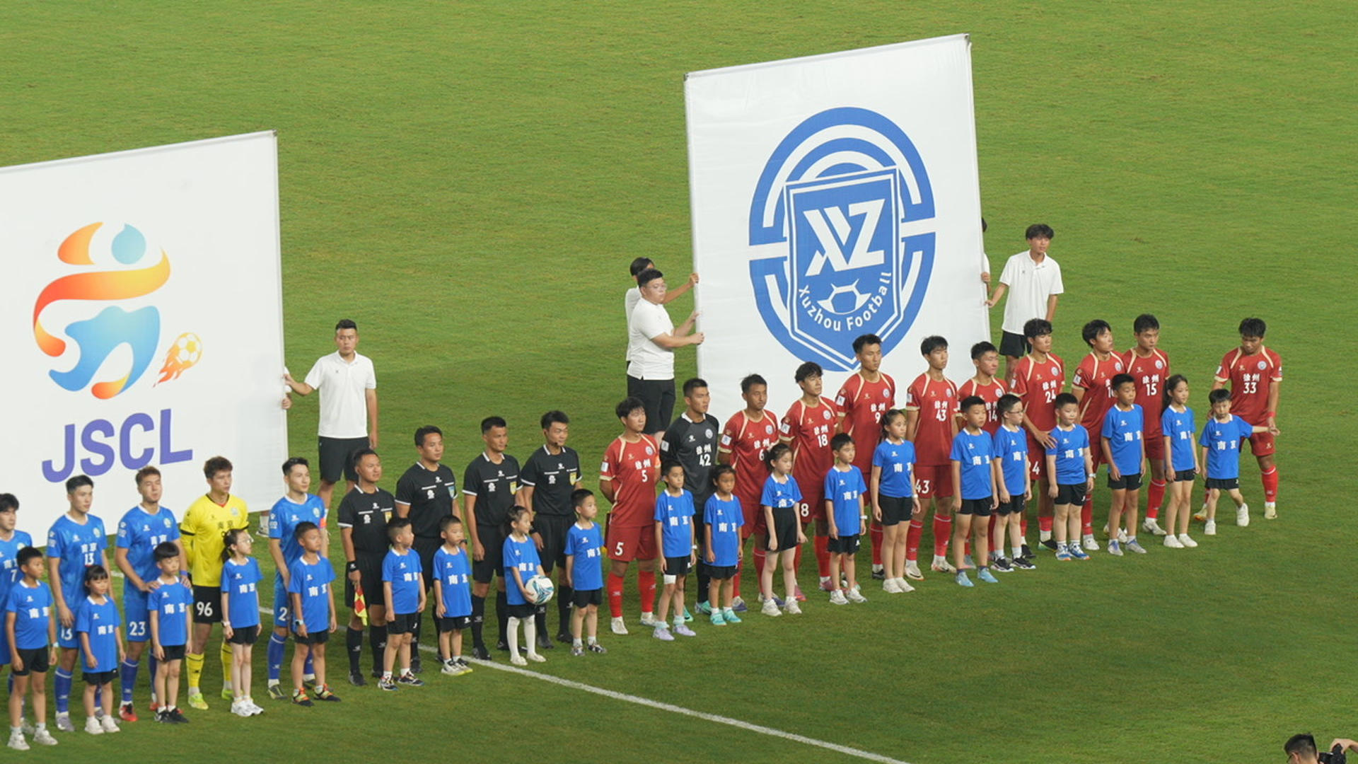 Dos equipos forman en el centro del campo antes de un partido de la Superliga de Fútbol de Jiangsu, una competición amateur que ha convertido a trece urbes chinas orgullosas de su identidad en un mosaico de Ciudades Estadio. EFE/Cadena estatal china CGTN/ SOLO USO EDITORIAL/SOLO DISPONIBLE PARA ILUSTRAR LA NOTICIA QUE ACOMPAÑA (CRÉDITO OBLIGATORIO)