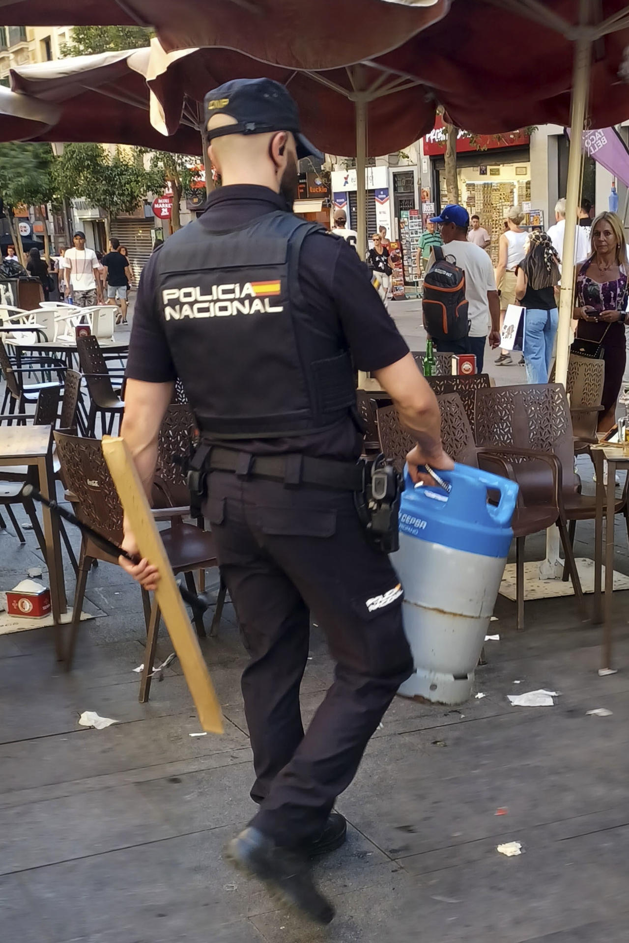 Un policía se lleva la bombona que amenazaba con explotar el hombre atrincherado en el centro de Madrid. La Policía ha detenido a esa persona que se había atrincherado en una vivienda de la calle Montera, junto a la Gran Vía de Madrid. El hombre, con antecedentes policiales, ha sido reducido tras la intervención de efectivos de la Unidad de Prevención y Reacción de la Policía. EFE/Antonio del Rey
