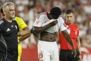 El defensa del Sevilla Tanguy Nianzou (c) se retira lesionado durante el partido de la sexta jornada de LaLiga que Sevilla FC y Villarreal CF disputaron en el estadio Sánchez-Pizjuán, en Sevilla. EFE/José Manuel Vidal