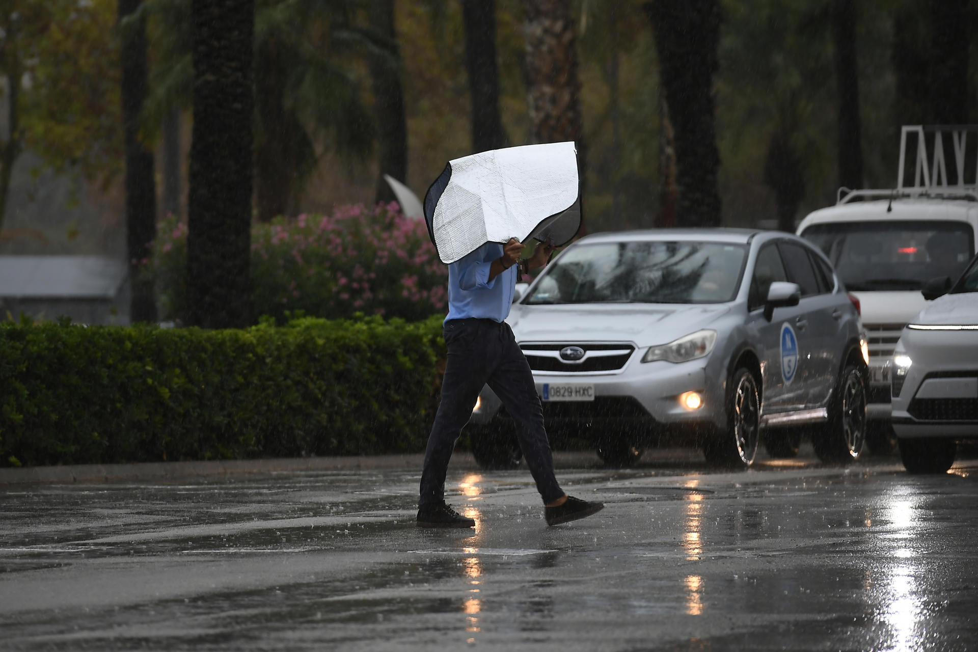 Un hombre se protege de la lluvia en Palma de Mallorca. EFE/Miquel A. Borrás