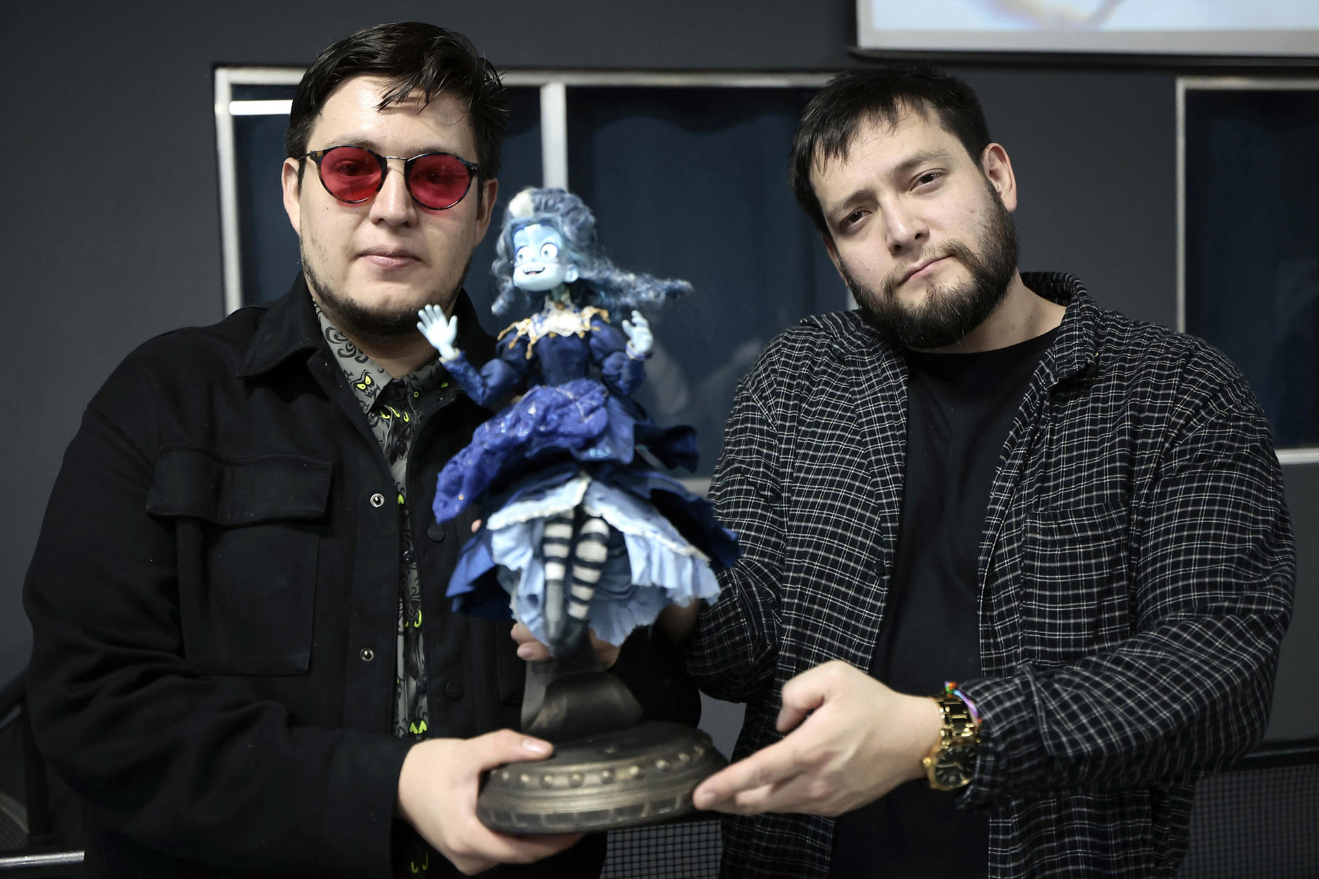 Los cofundadores de la casa productora Cinema Fantasma, Roy Ambriz (i) y Arturo Ambriz (d) posan con una figura del personaje de la película 'Soy Frankelda' este lunes, en Ciudad de México (México). EFE/ José Méndez
