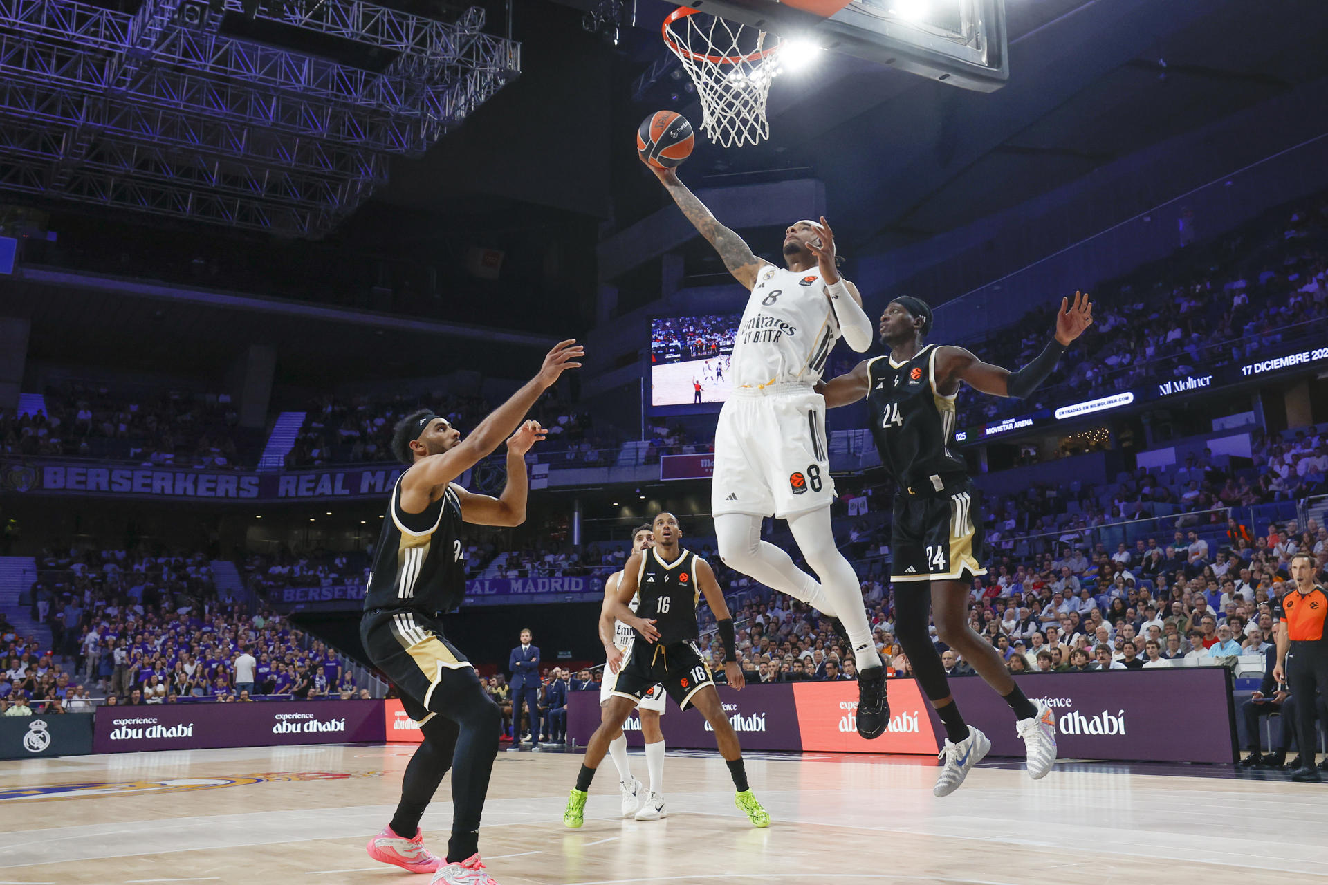 El alero estadounidense del Real Madrid Chuma Okeke (c) entra a canasta ante dos rivales del Asvel durante el partido de la tercera jornada de la temporada regular de la Euroliga que disputan este jueves en el Movistar Arena de Madrid. EFE/Juanjo Martín
