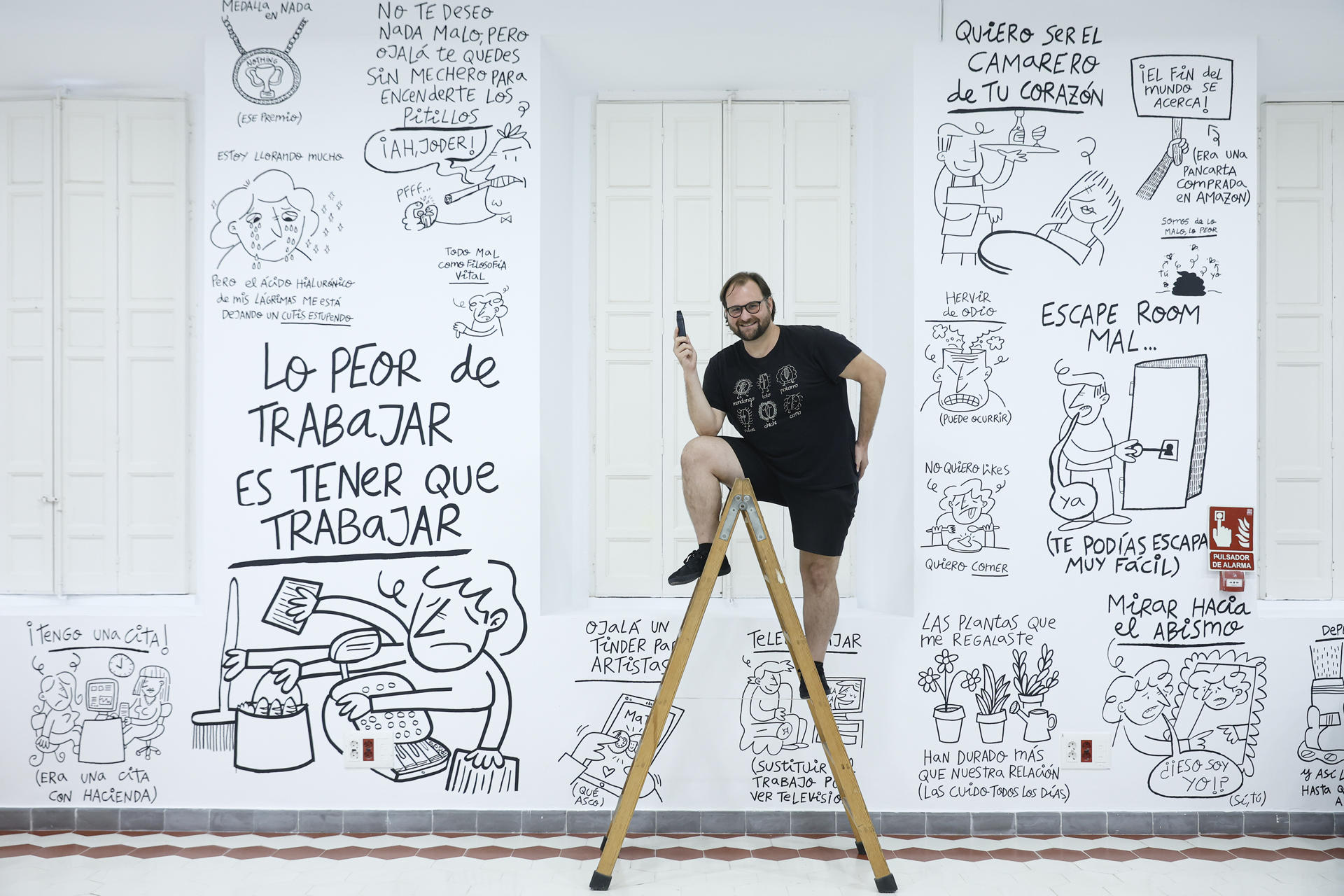 El dibujante Omar Janaan (Marbella, 1988), posa durante una entrevista con EFE y señala parte de sus viñetas dibujadas en las paredes del centro de cultura contemporánea La Térmica, en Málaga, en una exposición en la que quiere demostrar que el humor "es la cúspide de la inteligencia humana, nos permite reírnos de todo y combate los miedos", con un humor que también mueve a la reflexión.EFE/Jorge Zapata.