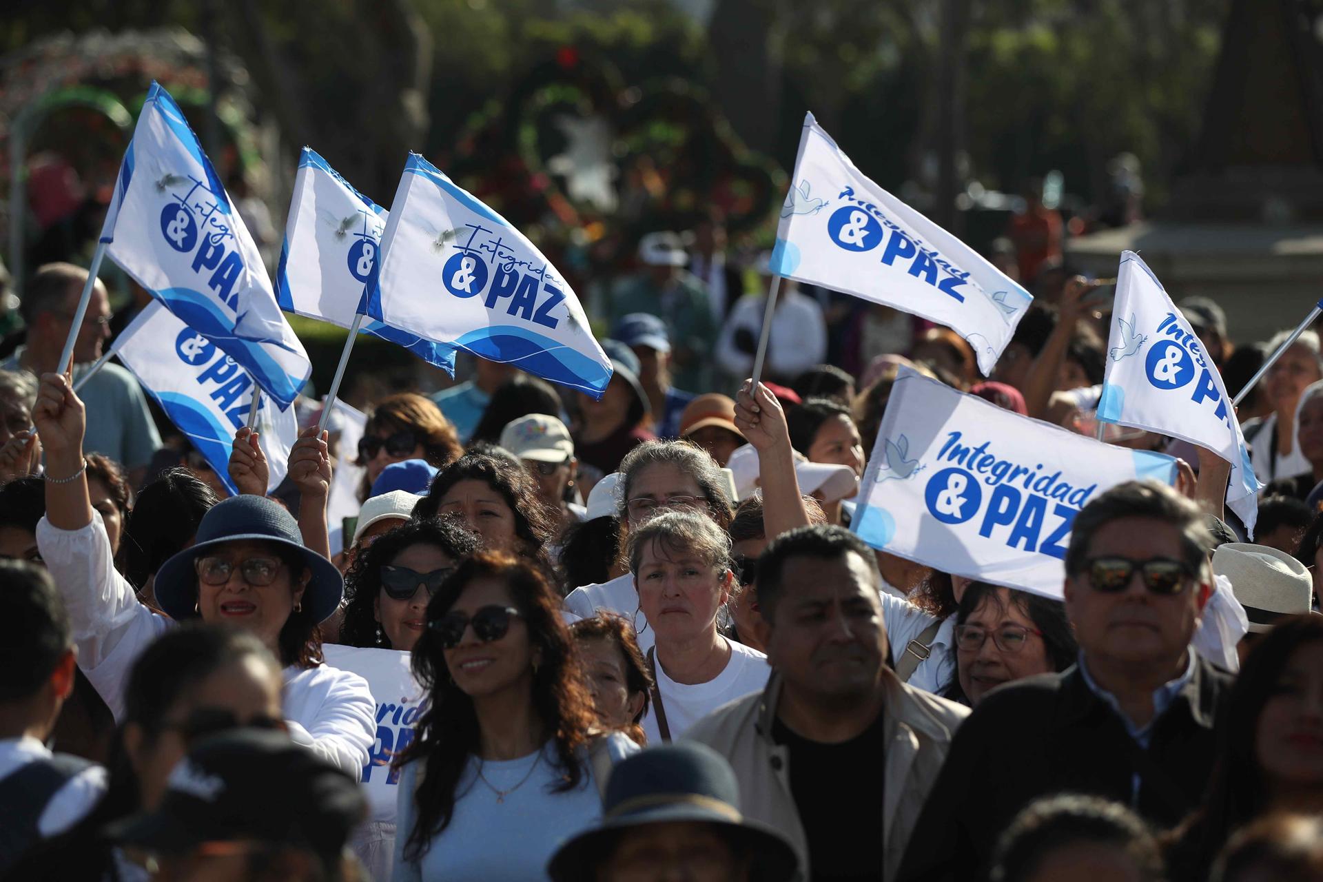 Personas sostienen banderas en un homenaje a Charlie Kirk este sábado, en Lima (Perú). EFE/ Paolo Aguilar
