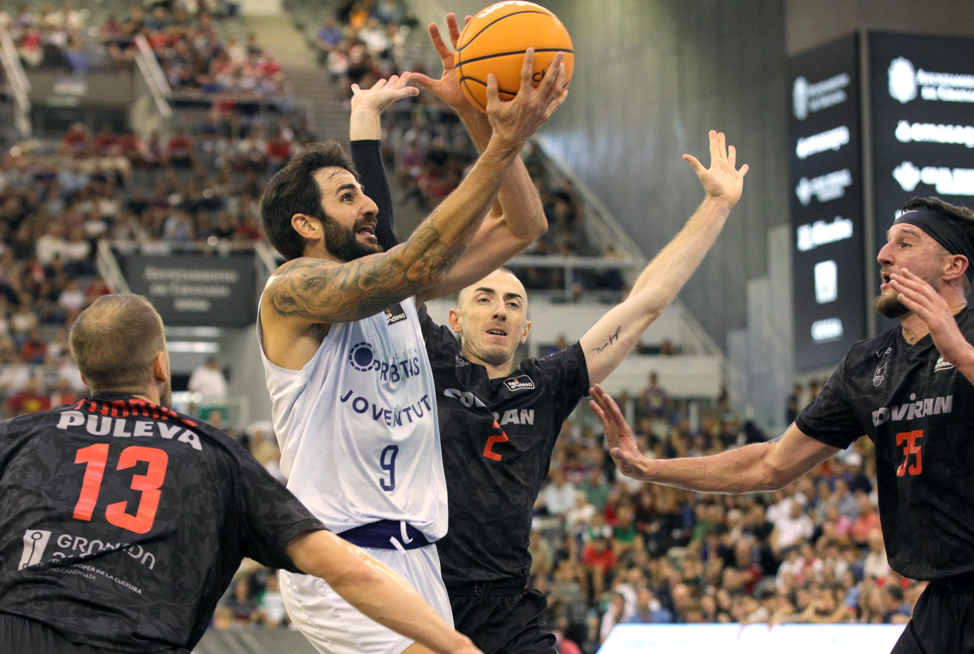 Los jugadores del Covirán Granada Matt Thomas (i), Jonathan Rousselle (2d) y Zach Hankins (d) rodean a Ricky Rubio, (2i), del Joventut de Badalona, durante el partido de la Liga Endesa contra el Joventut de Badalona, en el Palacio de los Deportes de Granada. EFE/ Pepe Torres