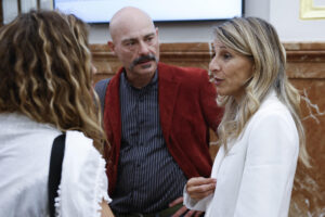 La vicepresidenta segunda y ministra de Trabajo y Economía Social, Yolanda Díaz (d), conversa con el diputado de Sumar Txema Guijarro (c) en los pasillos del Congreso de los Diputados, durante la sesión de control al Gobierno celebrada este miércoles en el Congreso. El Gobierno vuelve a enfrentarse en el Congreso a una jornada difícil en la que quiere sacar adelante la ley de Movilidad Sostenible, y en ambos casos ya solo depende de Podemos. EFE/ Chema Moya
