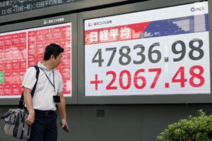 Un transeúnte fue captado este lunes, 6 de octubre, al observar una pantalla con los índices del mercado de valores de la Bolsa de Tokio, donde su principal indicador, el Nikkei, alcanzó su máximo histórico intradía (47.873,4 puntos), en Tokio (Japón). EFE/Franck Robichon