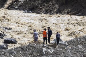 People look on the river and the landslide in the village of Blatten, Switzerland, 01 June 2025. A large part of the Blatten village, located in the Loetschental Valley in the canton of Valais, was buried under masses of ice, mud, and rock on 28 May after several million cubic meters of rock fell from the Kleines Nesthorn mountain above the village, resulting in the collapse of the Birch Glacier. (deslizamiento de tierras, Suiza) EFE/EPA/CYRIL ZINGARO/Archivo