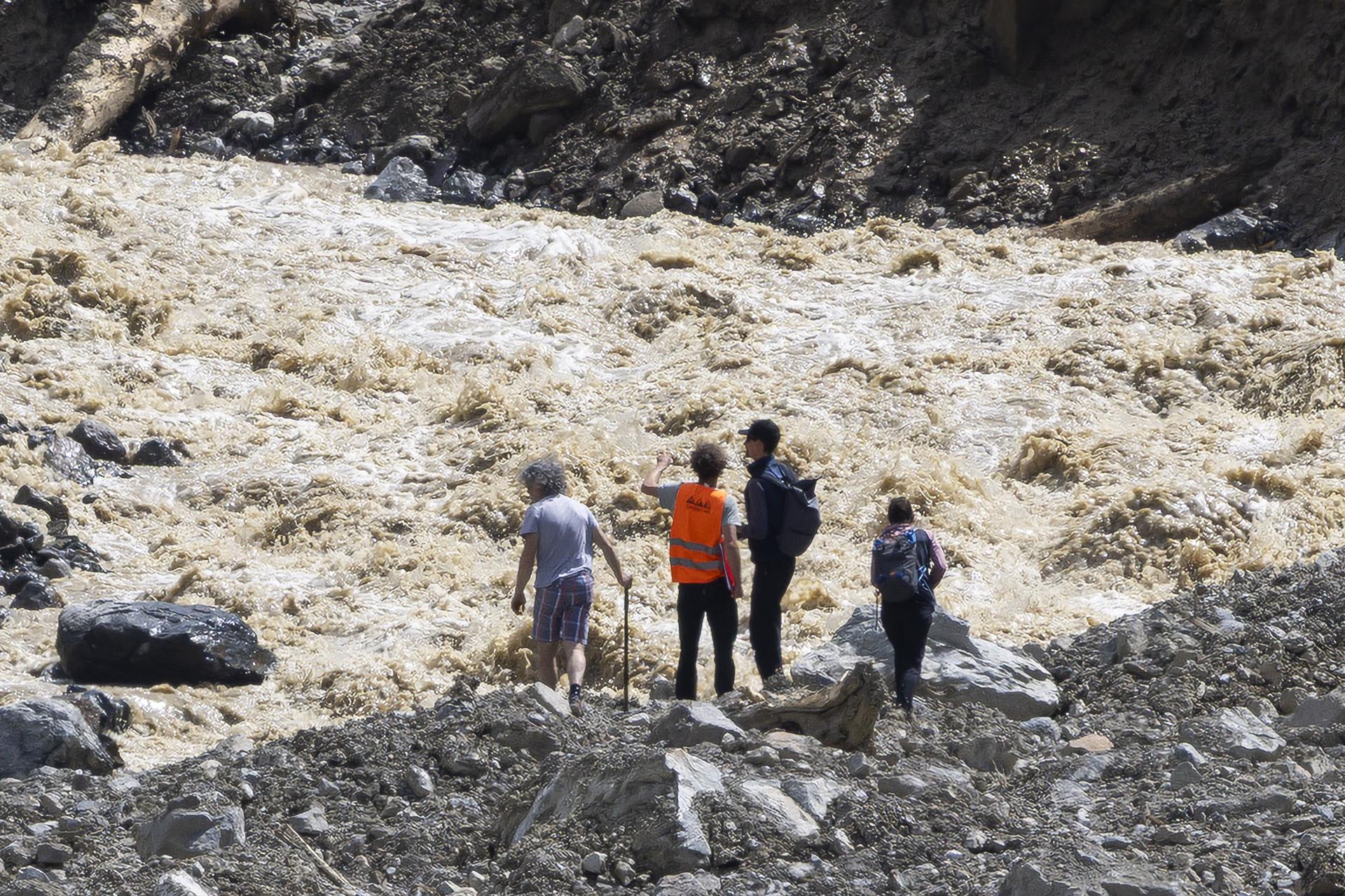 People look on the river and the landslide in the village of Blatten, Switzerland, 01 June 2025. A large part of the Blatten village, located in the Loetschental Valley in the canton of Valais, was buried under masses of ice, mud, and rock on 28 May after several million cubic meters of rock fell from the Kleines Nesthorn mountain above the village, resulting in the collapse of the Birch Glacier. (deslizamiento de tierras, Suiza) EFE/EPA/CYRIL ZINGARO/Archivo