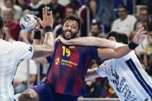 El lateral del Barça Timothey N'Guessan (c) lanza a puerta defendido por Imanol Garciandía (d), del OTP Bank, durante el partido correspondiente a la temporada regular de la Liga de Campeones de Balonmano que Barça y OTP Bank-Pick Szeged disputan hoy jueves en el Palau Blaugrana. EFE/ Enric Fontcuberta.