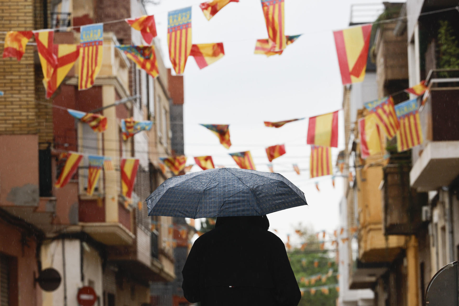 En la imagen de archivo, dos personas bajo la lluvia en una calle de Valencia. EFE/Manuel Bruque