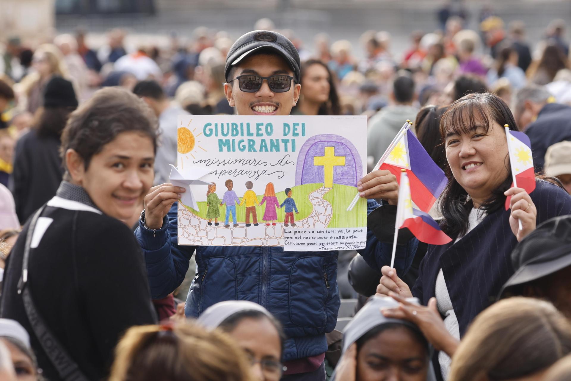 Peregrinos con banderas de Filipinas sostienen un cartel del "Jubileo de los migrantes" al asistir este domingo a la misa oficiada por el papa León XIV con motivo del Jubileo dedicado al mundo misionero y de los migrantes, en la Plaza de San Pedro del Vaticano. EFE/EPA/FABIO FRUSTACI