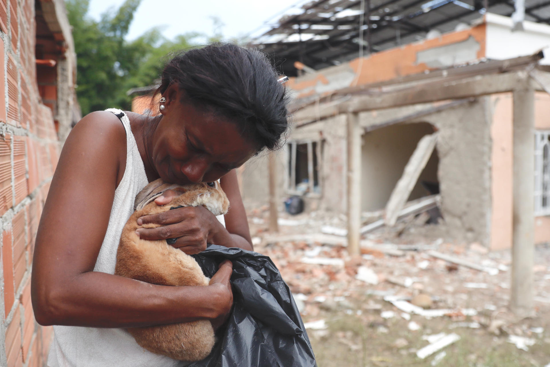 Una mujer abraza a su mascota tras una explosión este 9 de octubre de 2025, en Robles, Jamundí (Colombia). EFE/ Ernesto Guzmán