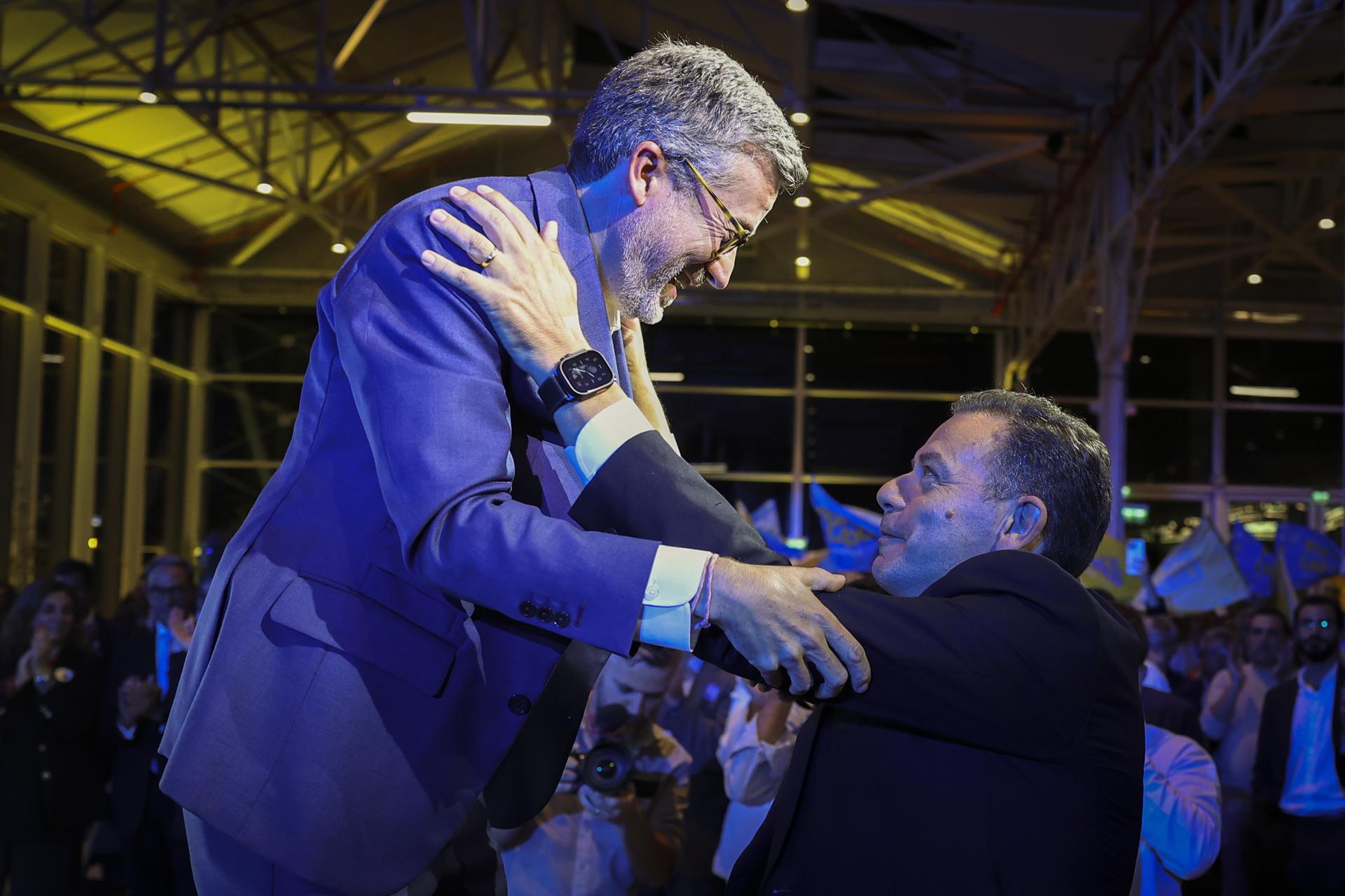El primer ministro de Portugal y presidente del Partido Social Demócrata (PSD), Luis Montenegro (d), al saludar al alcalde y candidato a la reelección para el Ayuntamiento de Lisboa, Carlos Moedas (i), durante un evento de cierre de campaña, este jueves, 9 de octubre, en la capital portuguesa. EFE/Antonio Pedro Santos