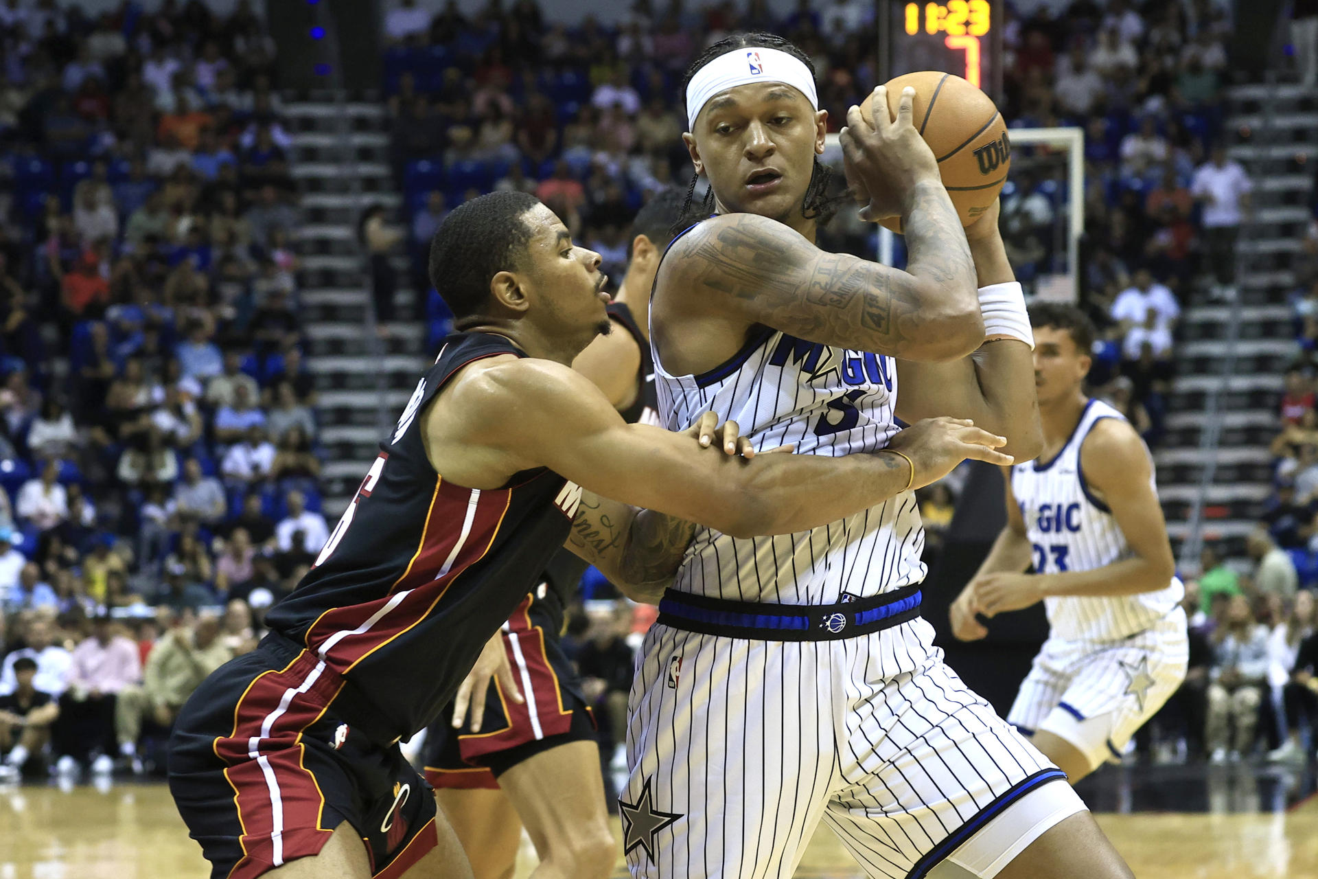 Paolo Benchero (d) de Orlando Magic disputa el balón con Kesha Johnson de Miami Heat este sábado en un partido de la pretemporada de la NBA jugado en el Coliseo José Miguel Agrelot de San Juan (Puerto Rico). EFE/ Thais Llorca
