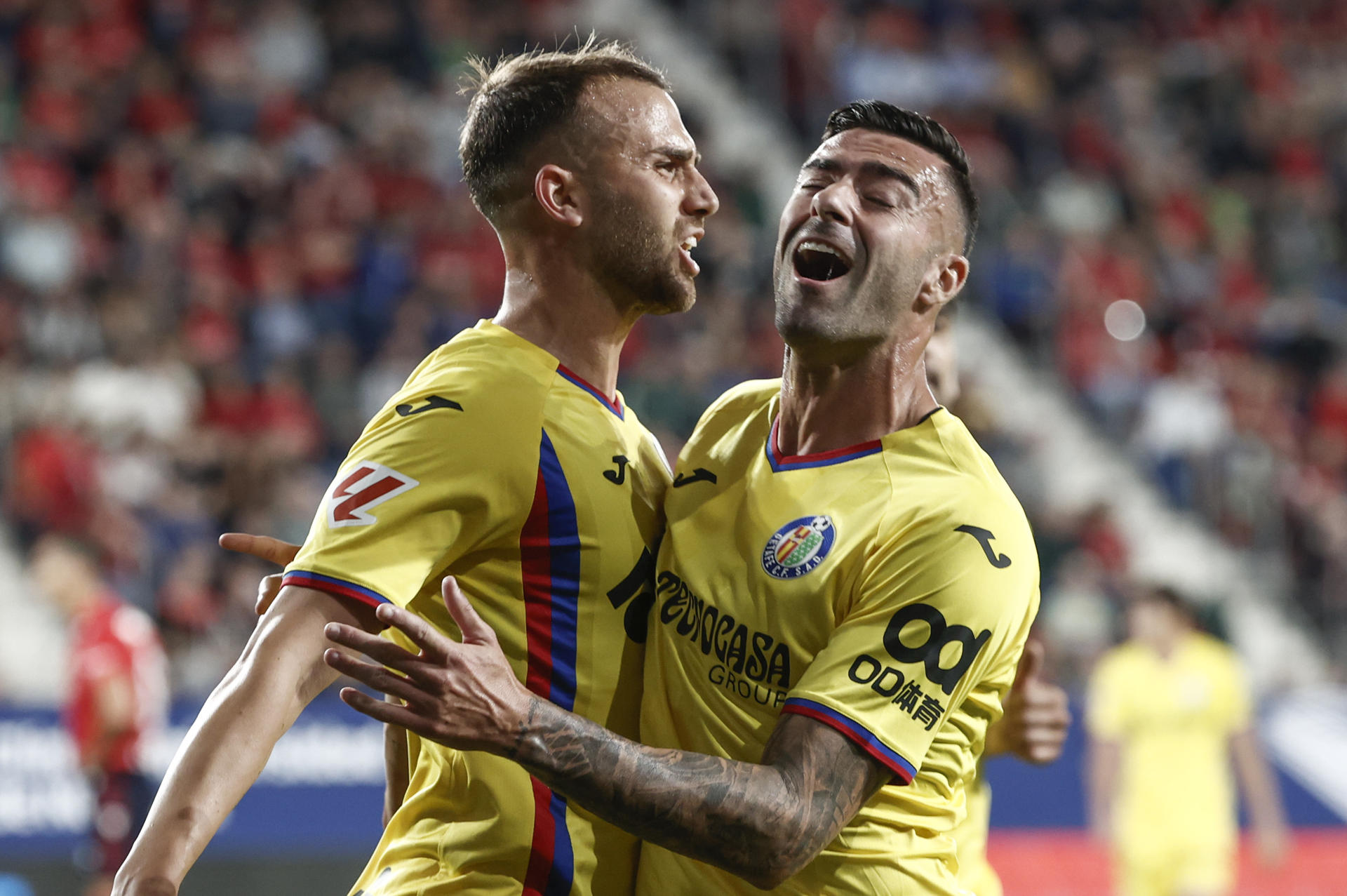 El delantero del Getafe Borja Mayoral (i) celebra con Diego Rico tras marcar ante Osasuna, durante el partido de LaLiga de fútbol que CA Osasuna y Getafe CF disputan este viernes en el estadio de El Sadar, en Pamplona. EFE/Jesús Diges
