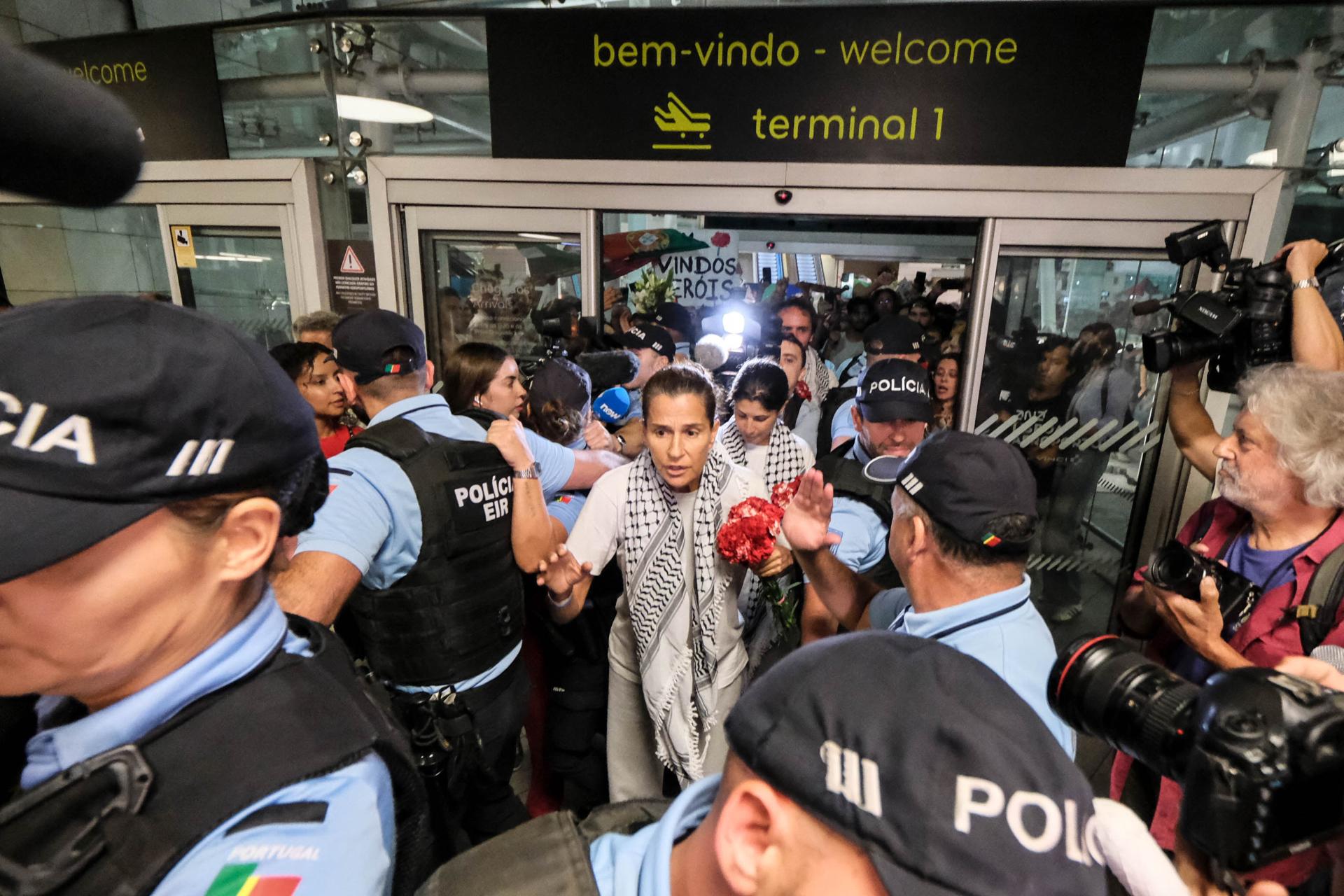 Mariana Mortágua (C-D) y Sofia Aparício (C-I), dos de los cuatro ciudadanos portugueses que participaron en la Flotilla Global Sumud y que habían estado detenidos en Israel desde el jueves, llegan de regreso al Aeropuerto de Lisboa, en Lisboa, Portugal. EFE/EPA/RUI MINDERICO
