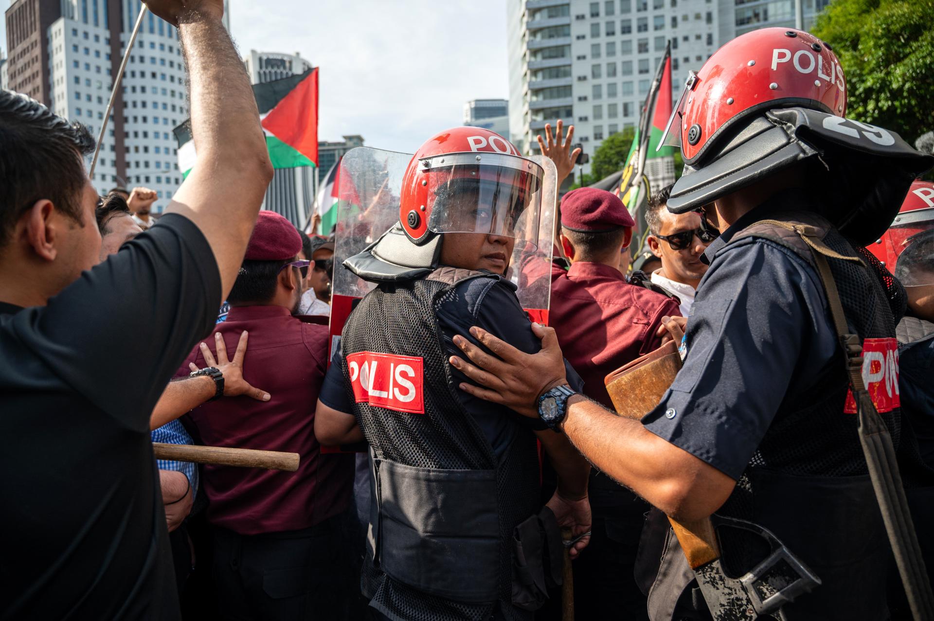 Kuala Lumpur (Malaysia), 02/10/2025.- Riot police stand guard as protesters demonstrate against Israeli forces' interception of vessels from the Global Sumud Flotilla (GSF) and the detention of Malaysian activists, outside the US Embassy in Kuala Lumpur, Malaysia, 02 October 2025. Thousands of demonstrators gathered to protest Israel's interception of a Gaza-bound aid flotilla and the detention of at least 12 Malaysian activists. (Protestas, Malasia) EFE/EPA/NAZIR SUFARI
