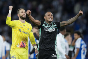 -El portero del Betis Pau López celebra junto a Natan Bernardo parar un penalti y la victoria de su equipo frente al Espanyol, durante el partido de la jornada 8 de LaLiga EA Sports entre le Espanyol y el Betis, este domingo en el RCDE Stadium en Barcelona.-EFE/ Enric Fontcuberta