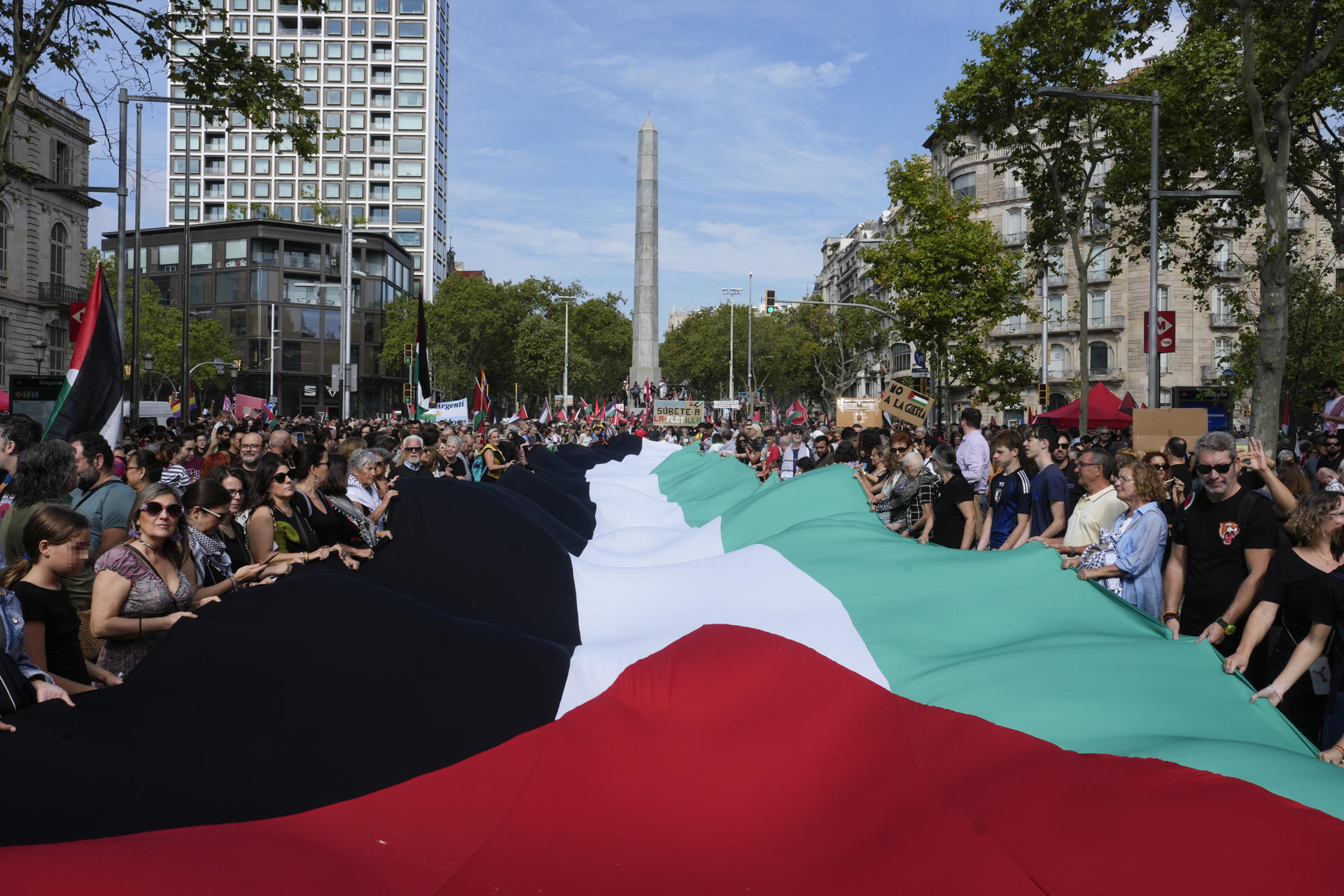 Participantes despliegan una bandera palestina durante la manifestación convocada por más de 600 entidades y sindicatos en apoyo a Palestina y contra el "genocidio" de Israel, este sábado, en Barcelona. EFE/ Enric Fontcuberta
