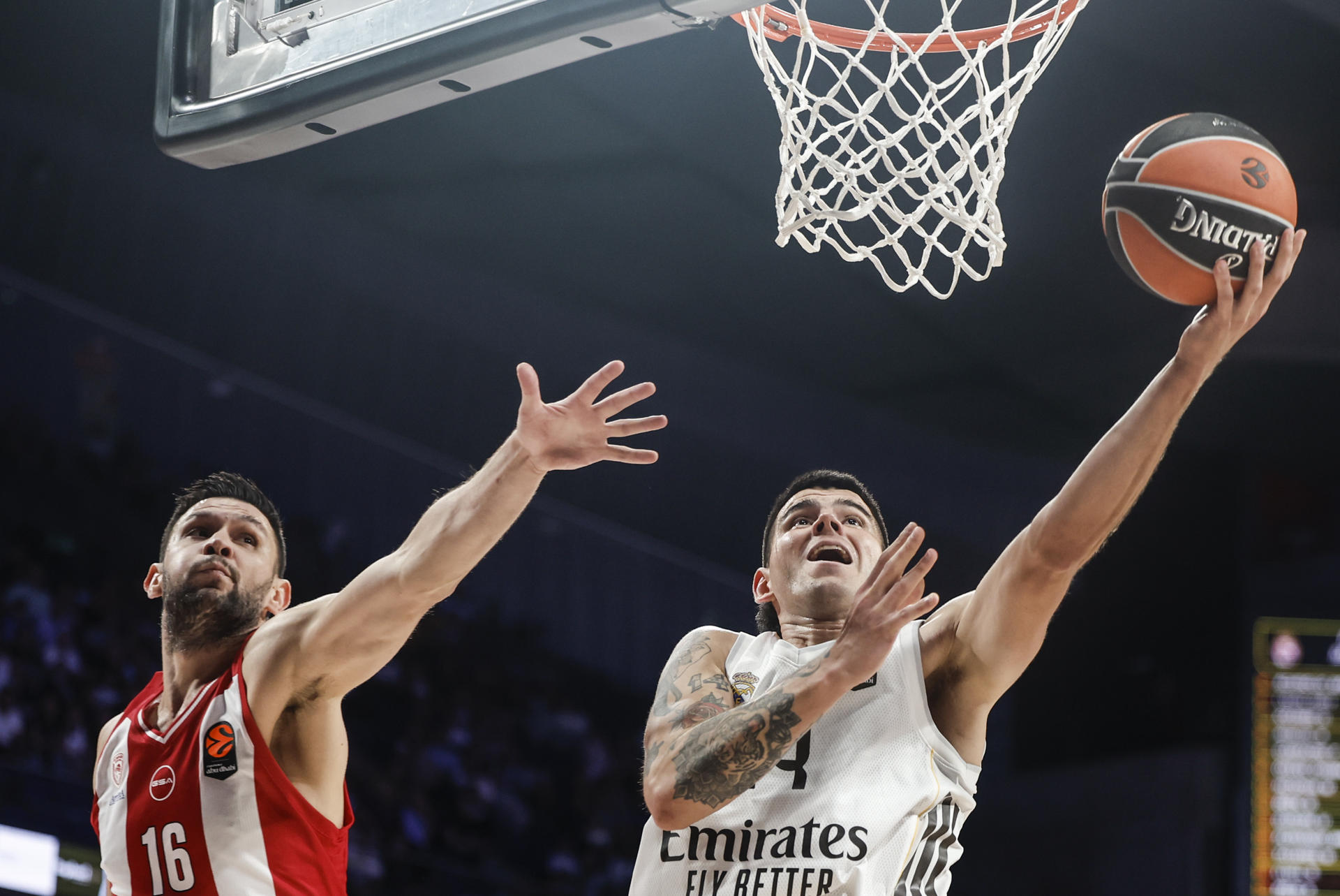 El alero del Real Madrid Gabriel Deck (d) entra a canasta defendido por Kostas Papanikolaou, de Olympiacos, durante el partido de EuroLiga que Real Madrid y Olympiacos. EFE/Sergio Pérez
