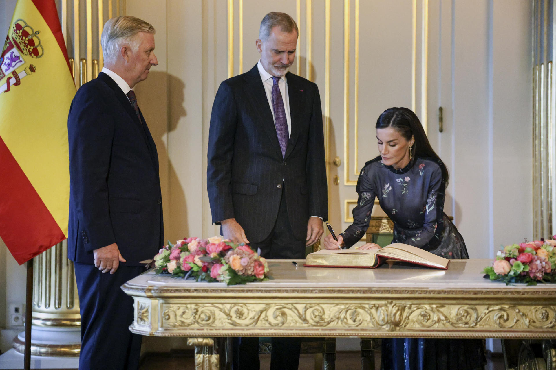 La reina Letizia (d) firma en el libro de visitas junto al rey Felipe vI (c) y el rey Felipe de Bélgica (i) en el Palacio Real de Bruselas, este martes, durante la visita oficial de los reyes de España a Bélgica. EFE/ Pablo Garrigós
