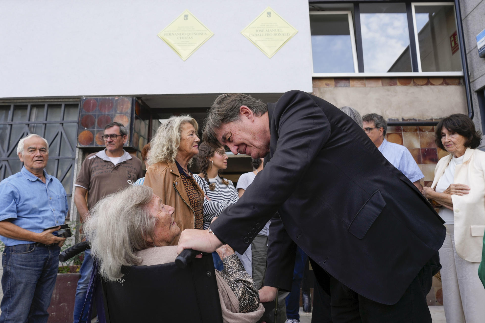 El director del Instituto Cervantes, Luis García Montero (d), saluda a María Josefa Ramis Cabot, viuda de José Manuel Caballero Bonald, durante el homenaje a los escritores Caballero Bonald y Fernando Quiñones ante el edificio en el que vivieron, este miércoles en Madrid. EFE/ Borja Sánchez-Trillo