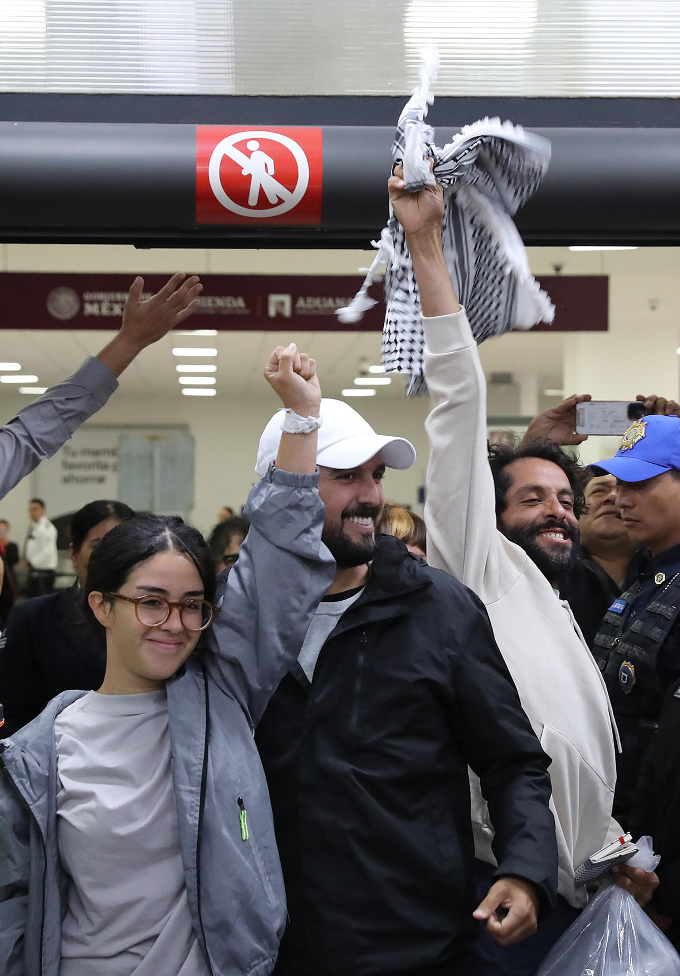De izquierda a derecha, los activistas mexicanos Arlín Medrano, Carlos Pérez y Diego Vázquez reaccionan este miércoles, a su llegada al Aeropuerto Internacional de la Ciudad de México (México). EFE/Mario Guzmán
