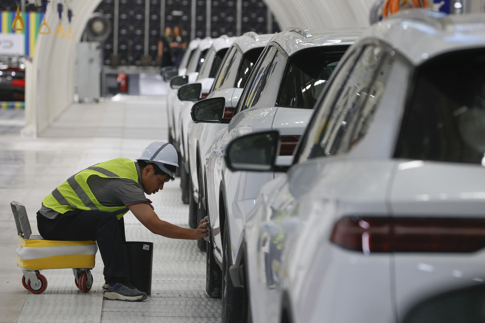 Una persona limpia un vehículo durante la inauguración de la fábrica de la empresa china Build Your Dreams (BYD), que será la base de la futura expansión en el mercado de vehículos eléctricos de América Latina este jueves, en Camaçari (Brasil). EFE/ Américo Roberto