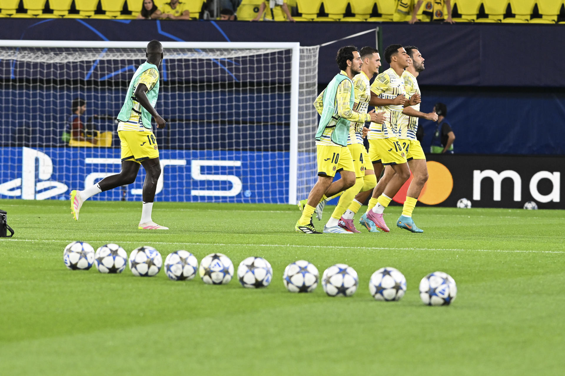 Los jugadores del Villarreal calientan antes de comenzar el partido de primera ronda de Liga de Campeones que Villarreal CF y Juventus de Turín disputan este miércoles en el estadio de La Cerámica. EFE/Andreu Esteban