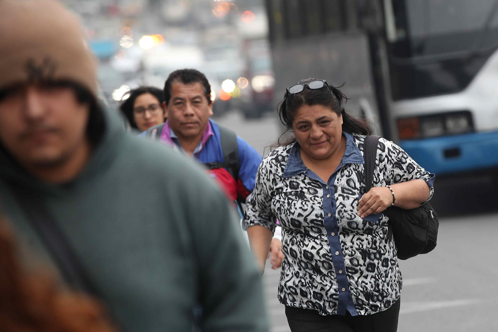 Personas caminan para utilizar un bus de servicio público este lunes, en Lima (Perú). EFE/ Paolo Aguilar
