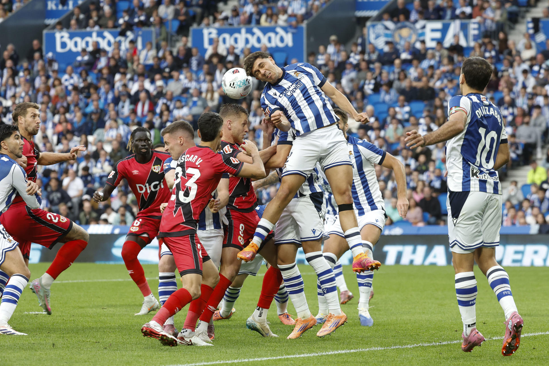El lateral de la Real Jon Aramburu (2-d) cabecea un balón ante varios jugadores del Rayo, durante el partido de LaLiga de fútbol que Real Sociedad y Rayo Vallecano disputan este domingo en el Real Arena, en San Sebastián. EFE/Jaun Herrero
