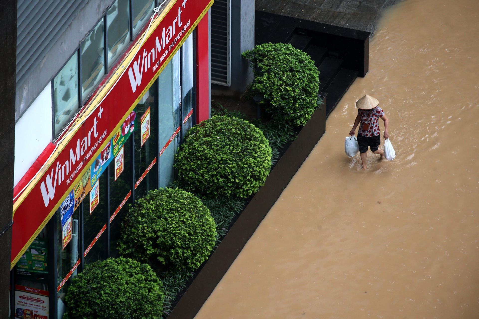 HANÓI (Vietnam), 07/10/2025.- A woman wades through a flooded street in Hanoi, Vietnam, 07 October 2025. Torrential rains triggered by Typhoon Matmo caused flooding in Hanoi’s streets on 07 October. EFE/EPA/LUONG THAI LINH
