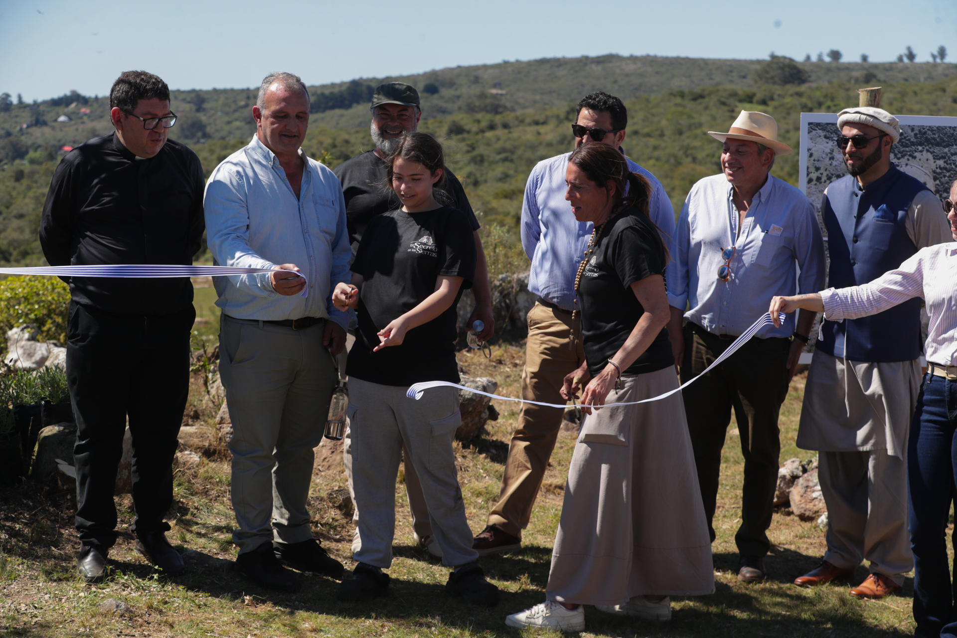 El secretario de la Presidencia de Uruguay, Alejandro Sánchez (c-atrás), el presidente de la Comunidad Musulmana en Uruguay, Yousaf Khan (d), y el párroco de la Parroquia de Minas, Fernando Pereira (i), fuero captados en la inauguración del símbolo interreligioso de paz de la emprendedora Noelia Franco (c-d), este jueves, 9 de octubre, en Villa Serrana (Uruguay). EFE/Alejandro Prieto