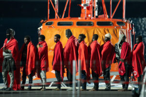 Personas de origen subsahariano delante de un barco de Salvamento Marítimo tras ser rescatados de una embarcación que transportaba a unas 50 al nordeste de Lanzarote. EFE/Adriel Perdomo