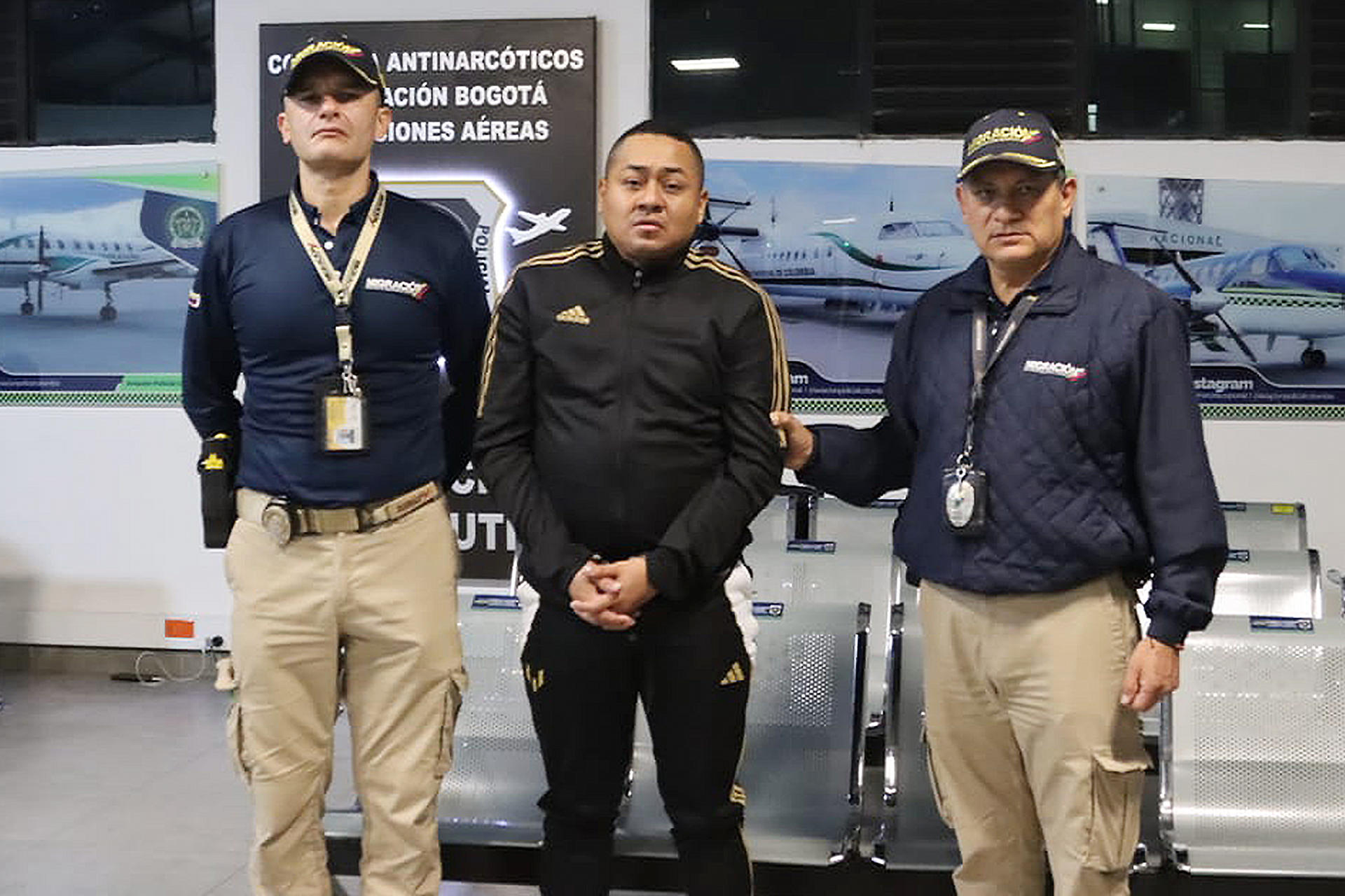 Fotografía cedida por Migración Colombia que muestra al ciudadano ecuatoriano Rolando Federico Gómez Quinde (c), alias Fede, custodiado por funcionarios de Migración Colombia este viernes, en Bogotá (Colombia). EFE/ Migración Colombia /SOLO USO EDITORIAL/ NO VENTAS/ SOLO DISPONIBLE PARA ILUSTRAR LA NOTICIA QUE ACOMPAÑA (CRÉDITO OBLIGATORIO)