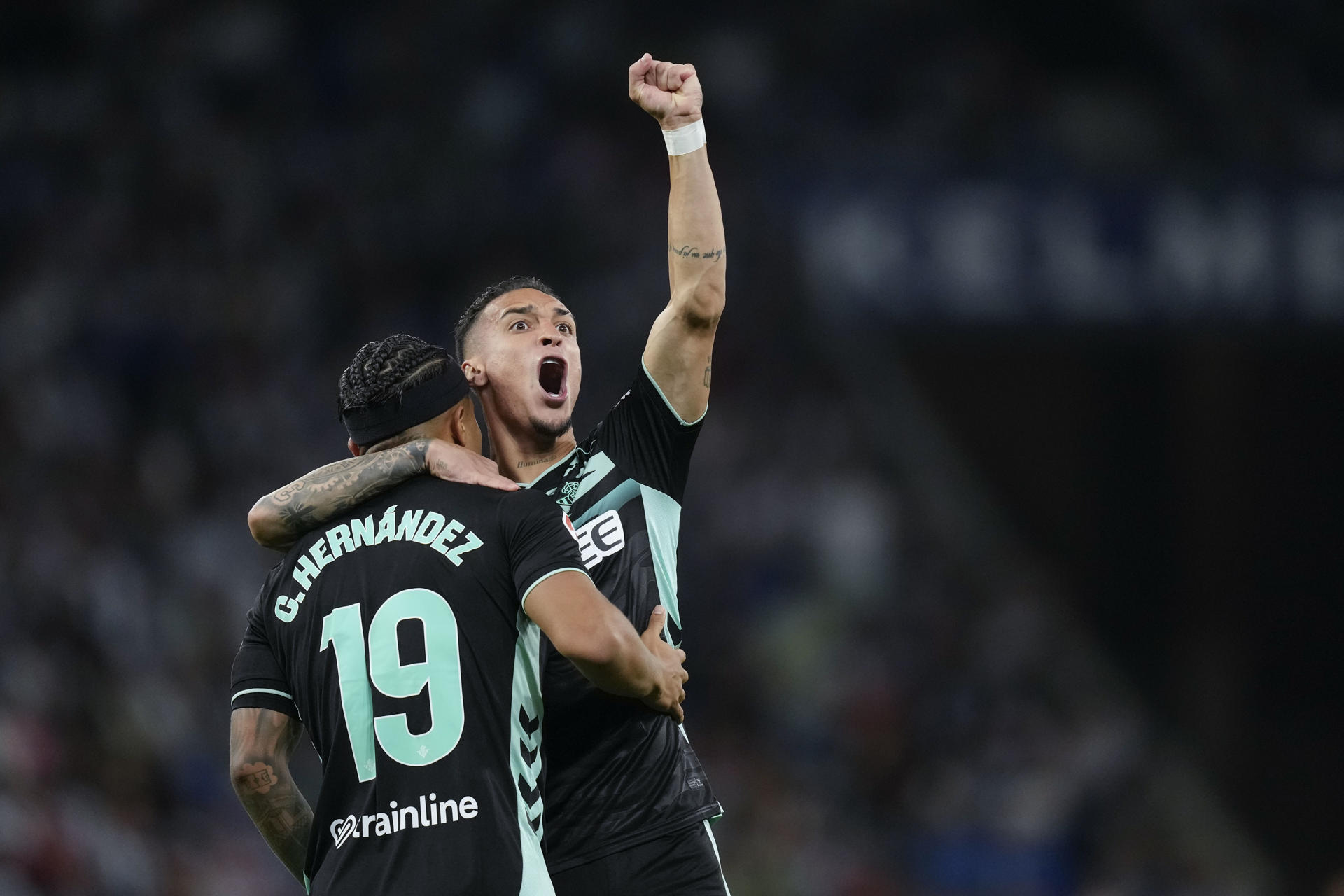 El jugador del Betis Cucho Fernández (i) celebra después de anotar contra el Espanyol durante un partido de LaLiga EA Sports de fútbol entre el conjunto catalán y el Betis en el RCDE Stadium en Barcelona. EFE/ Enric Fontcuberta

