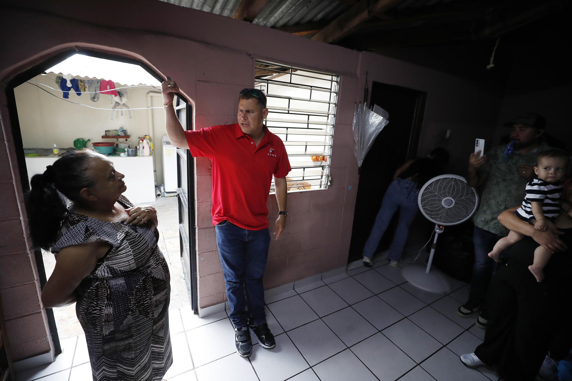 El periodista salvadoreño Mario Guevara (c) fue captado este viernes, 3 de octubre, al hablar sus familiares, en Apopa (El Salvador). EFE/Rodrigo Sura
